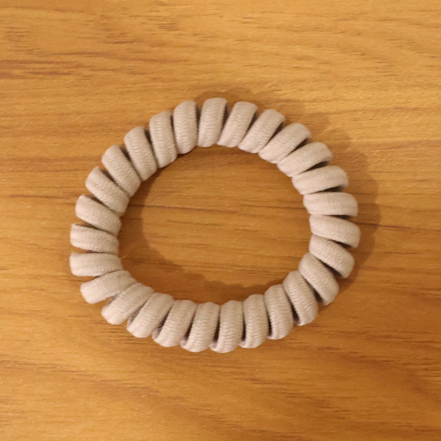 Multiple spiral coil hair bands in assorted shades, offering versatile styling.