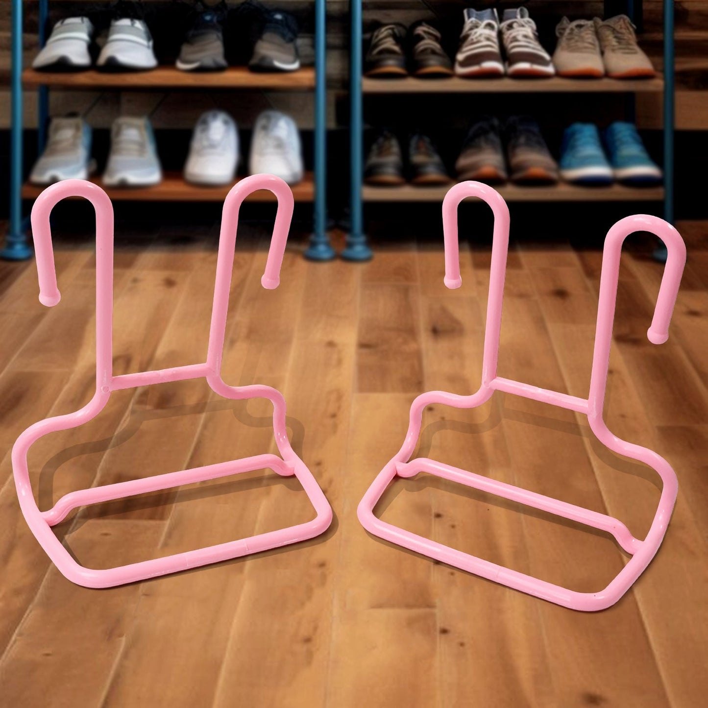 Two pink plastic shoe drying racks rest on a wooden floor in front of a shoe rack filled with various footwear.