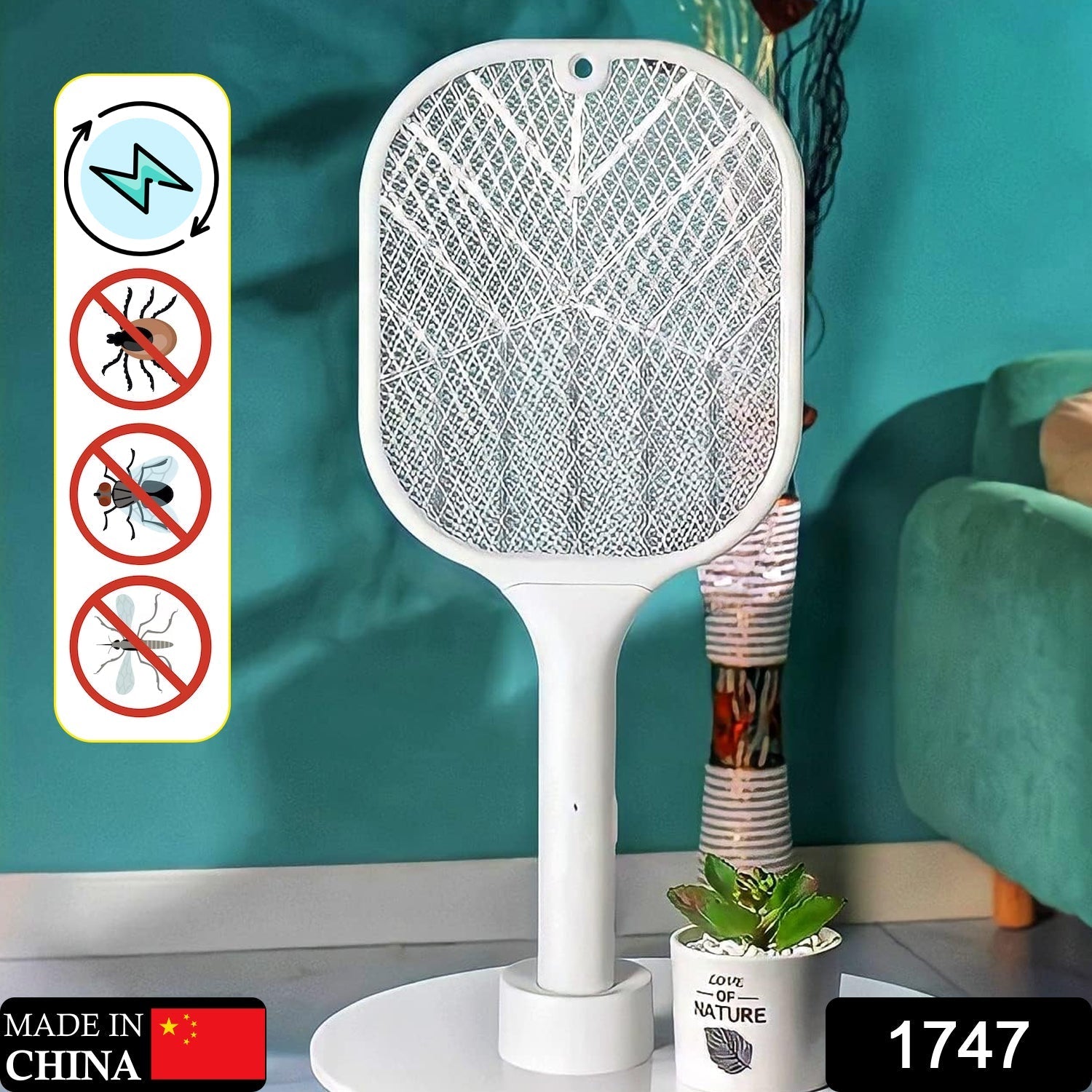 A white mosquito killer racket with a stand is positioned in a room with a teal wall and a green armchair.
