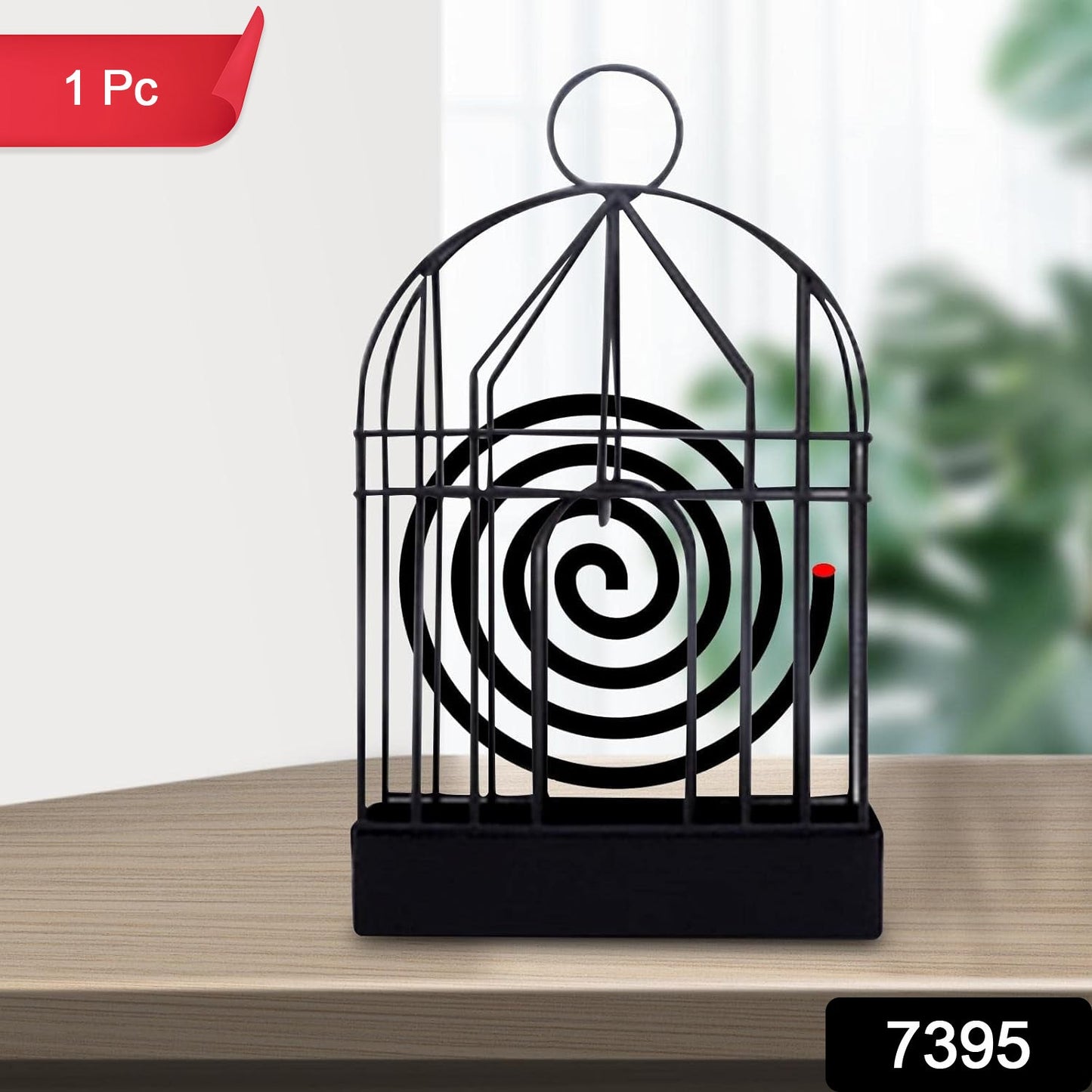 A black iron birdcage-style holder with a burning mosquito coil is on a wooden table, with a red