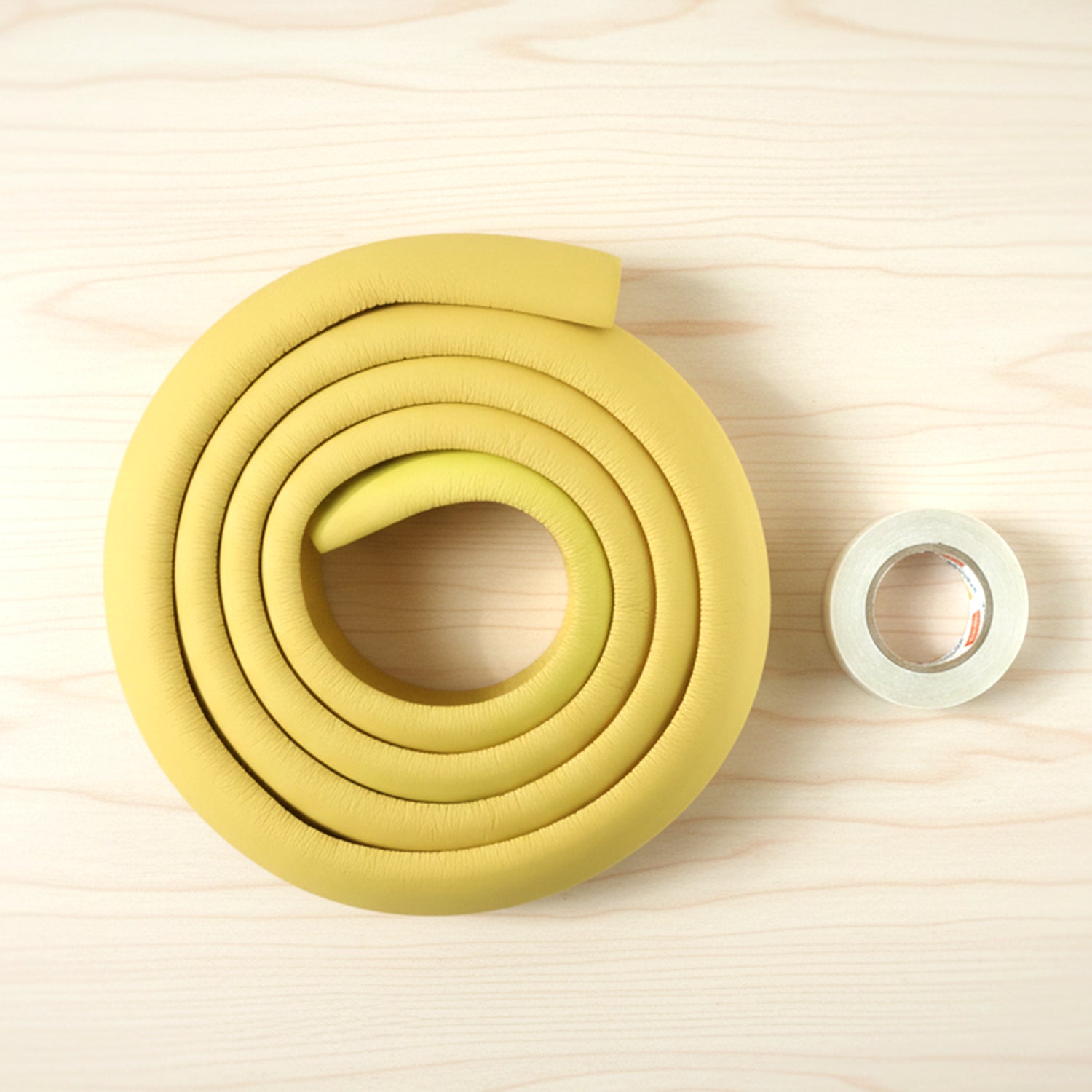 Soft rubber baby corner protector installed on a wooden table edge.
