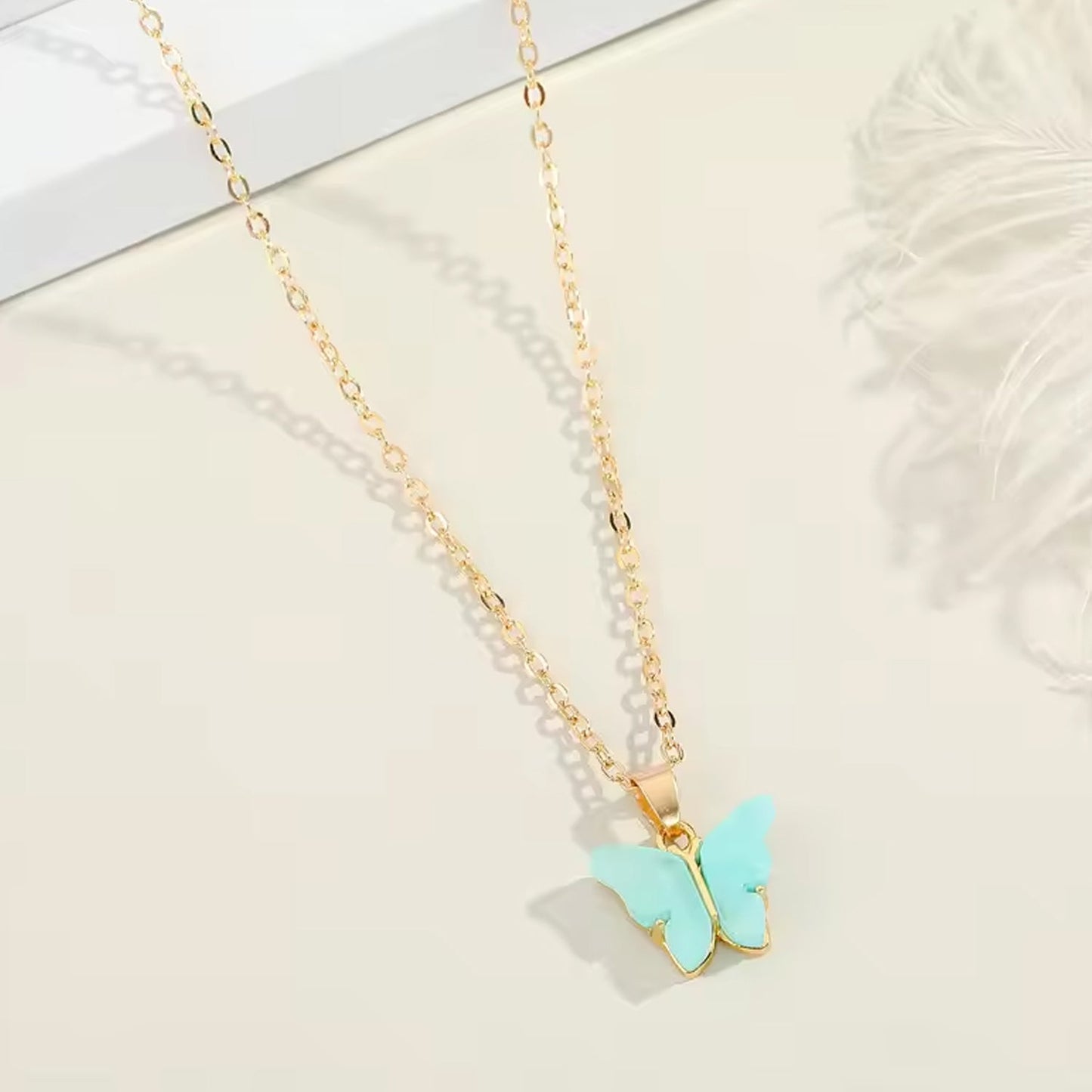 Assorted charm chain necklace with pink hearts and butterflies.