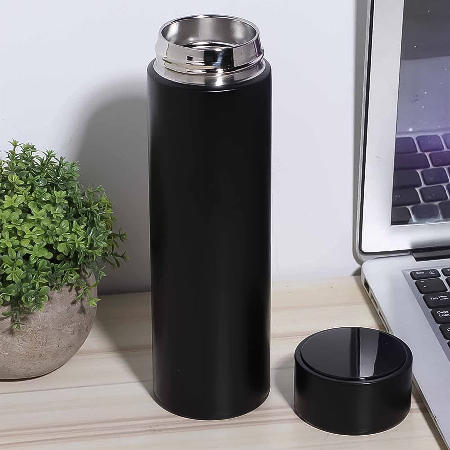Person holding the sleek 500ml insulated water bottle, ideal for travel.