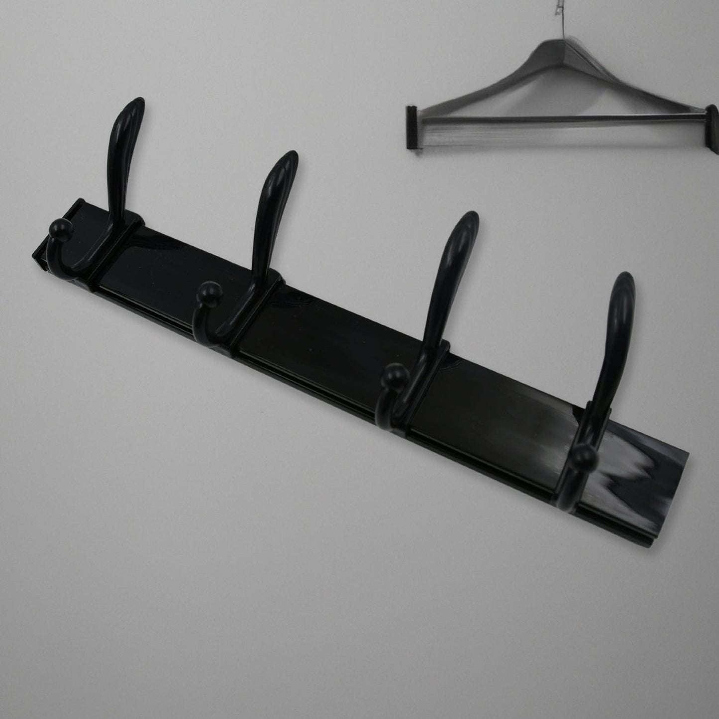 Top-down view of the 4-hook wall mount coat hanger holding various coats and hats.