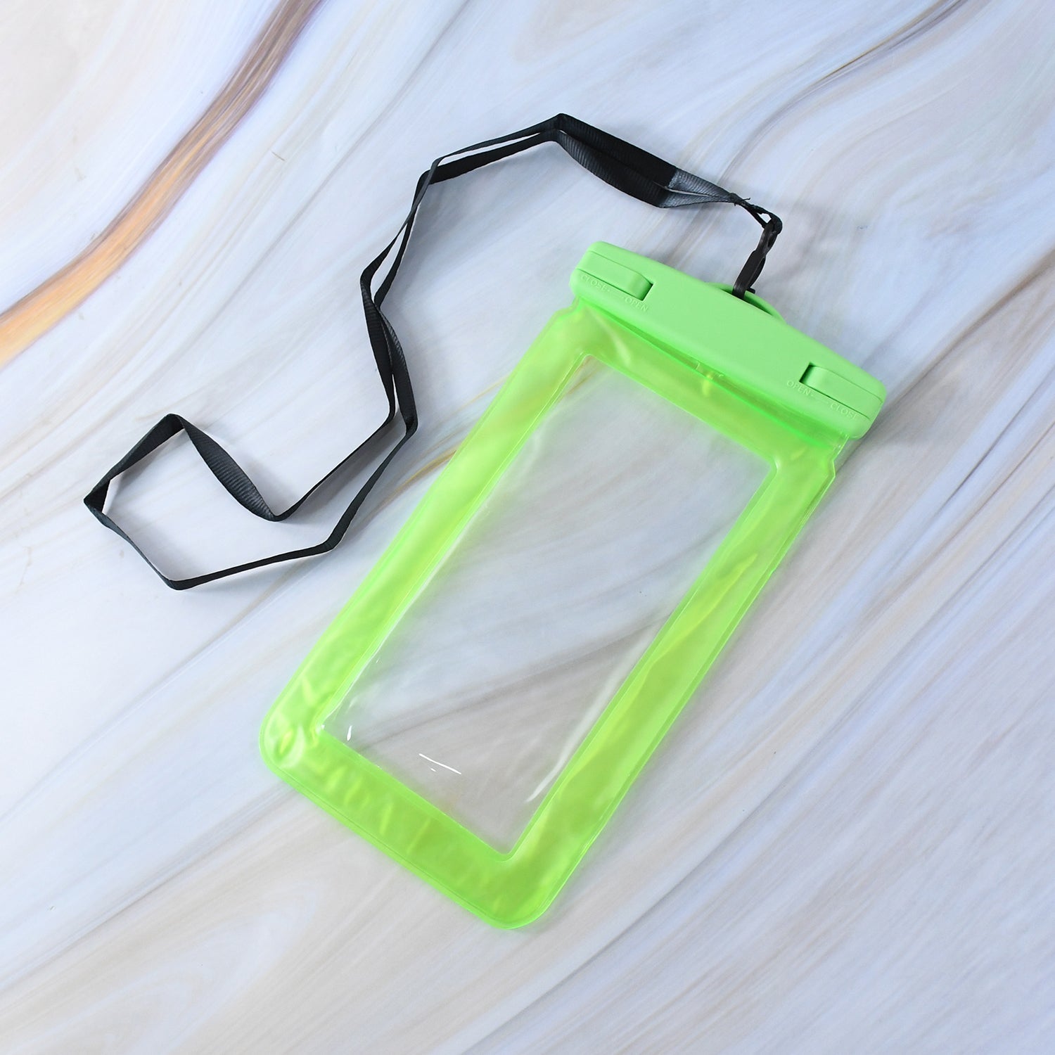 A translucent green empty phone pouch with a black lanyard lies on a white marble-patterned surface.