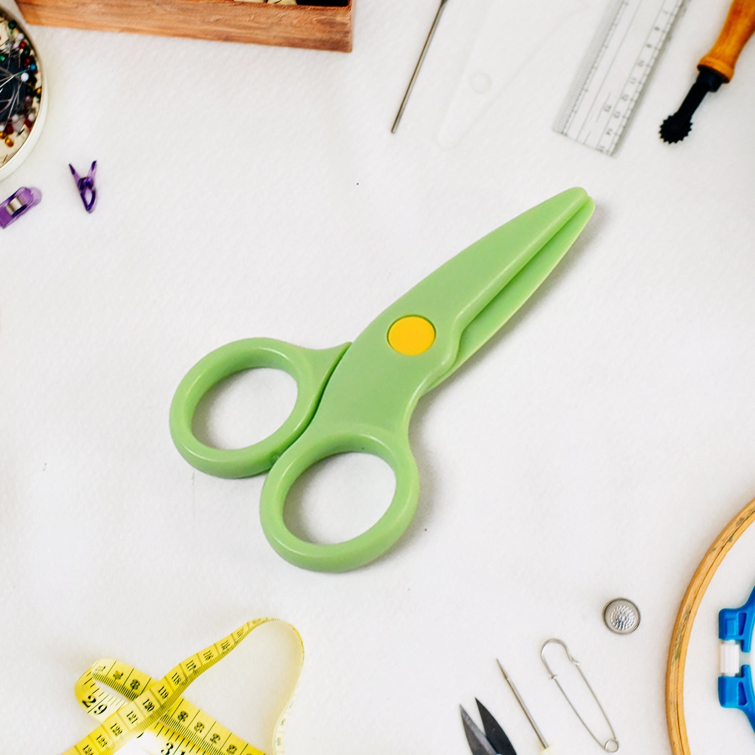 Plastic safety scissors placed on a craft table for toddlers