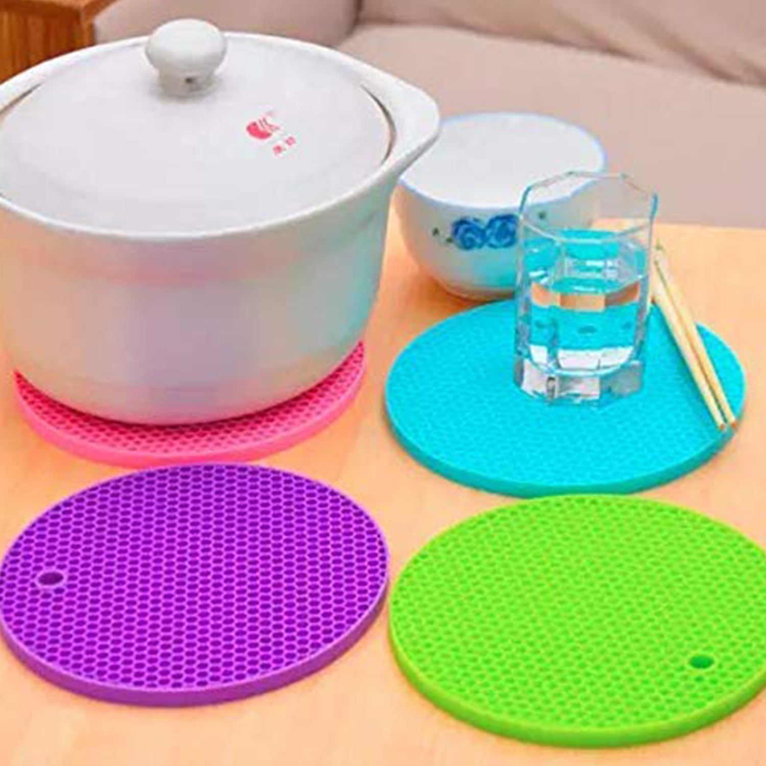Close-up of a red silicone hot pot mat, highlighting its textured design for better grip.