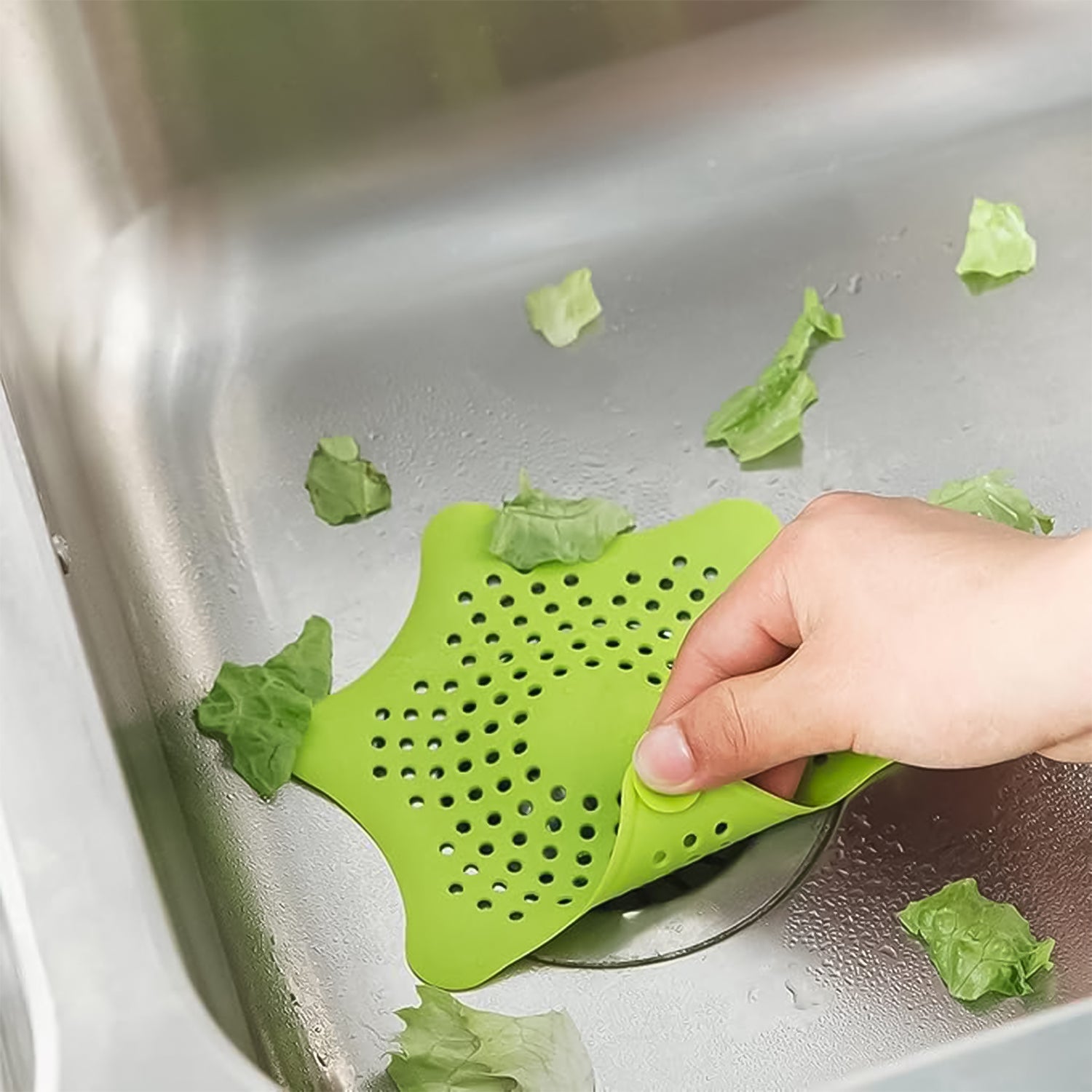 Starfish-shaped silicone drain strainer effectively catching debris in a kitchen sink.