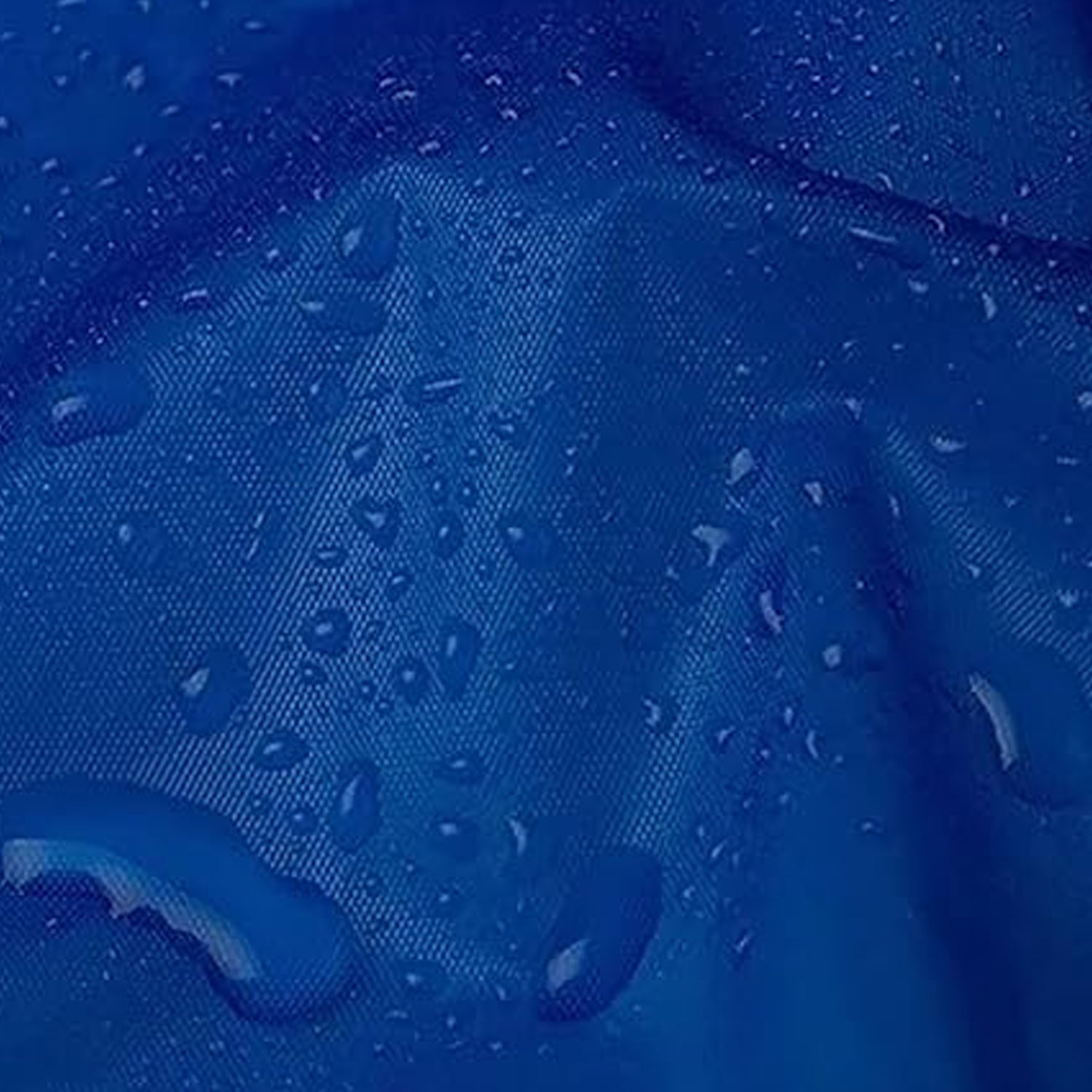 A close-up of a blue waterproof fabric with small water droplets beading on its surface.