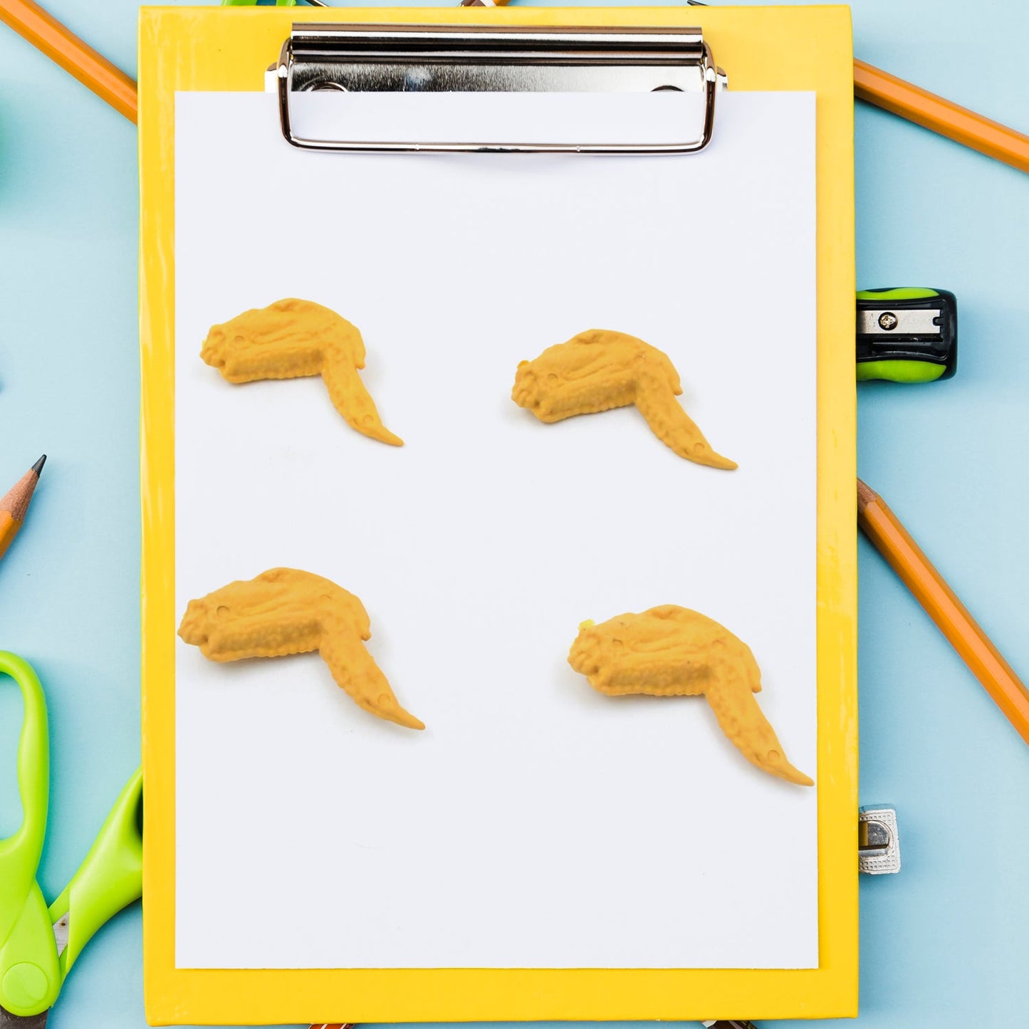 Side view of the chicken erasers, showing their three-dimensional form and playful appearance.