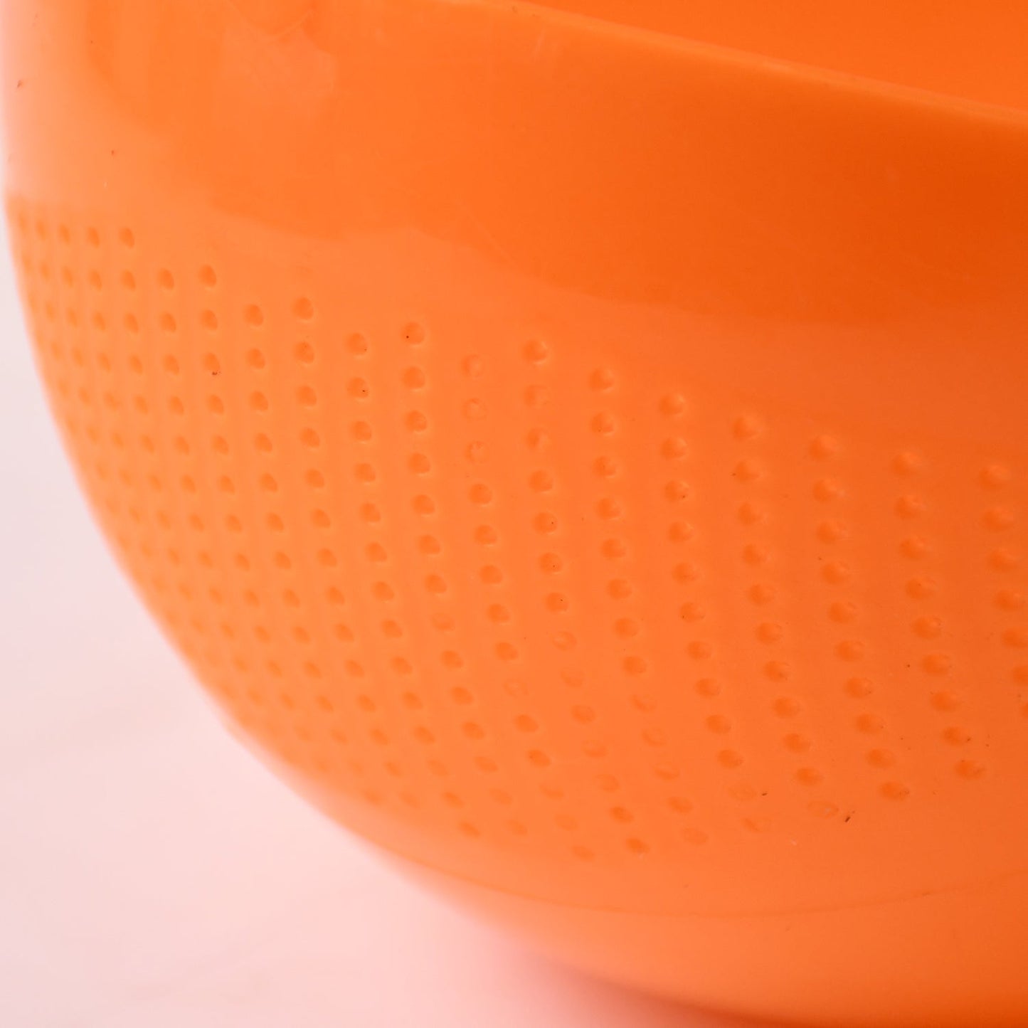 Clean plastic rice washing bowl strainer resting on a modern kitchen counter.