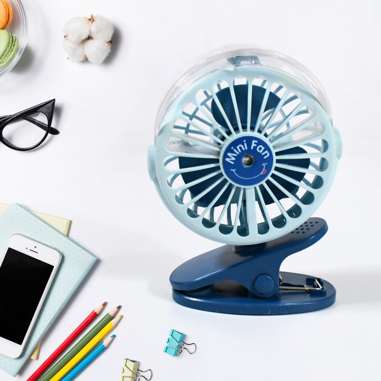 A person using the rechargeable mini fan for personal cooling on a desk.