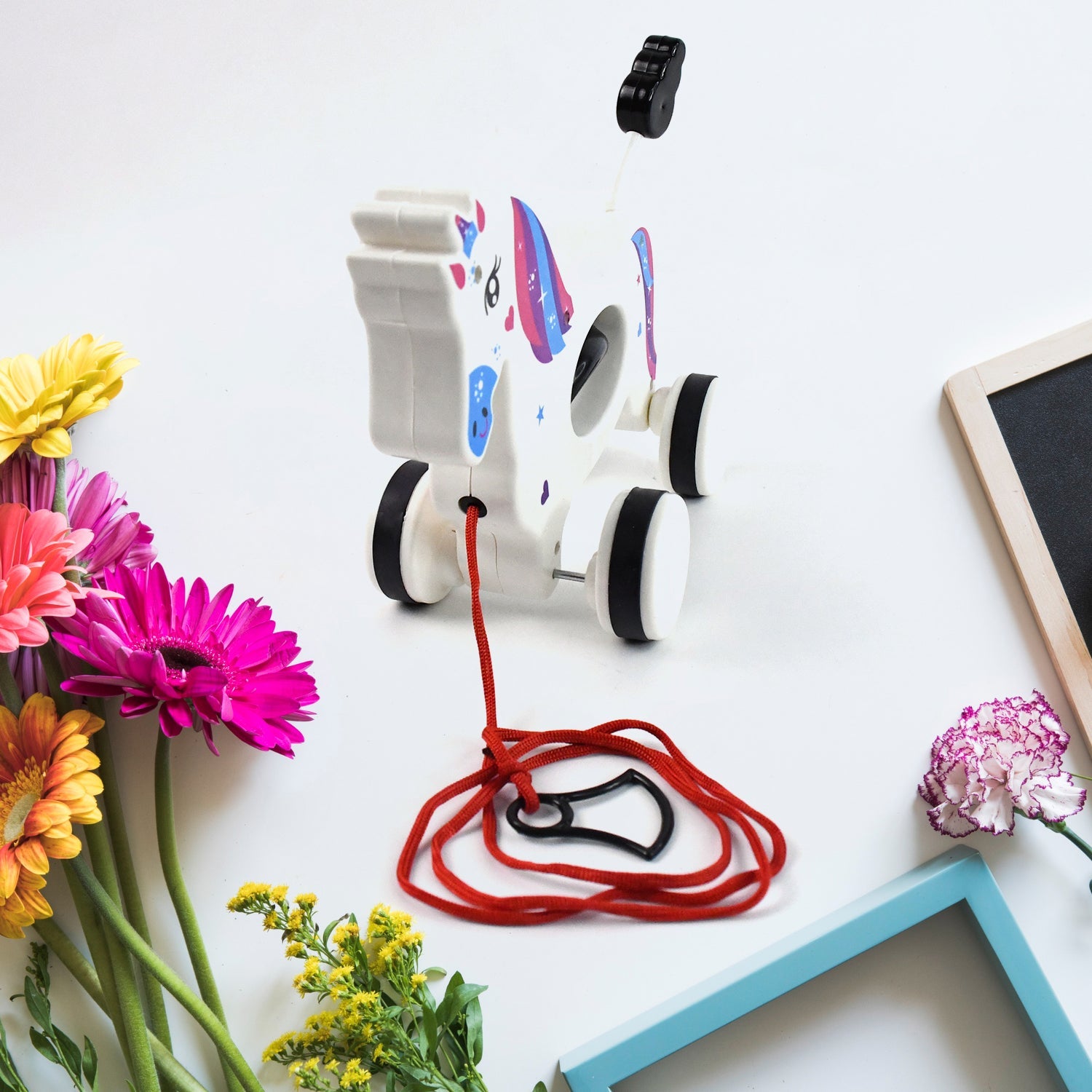 Side view showing smooth wheels of the Unicorn pull along toy for toddlers