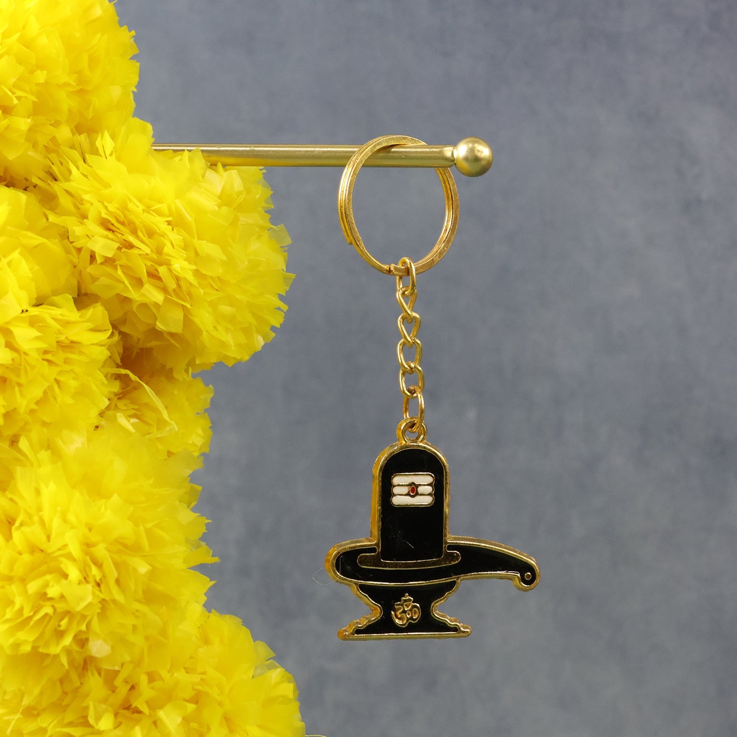 Golden Shivling keychain in protective blister packaging