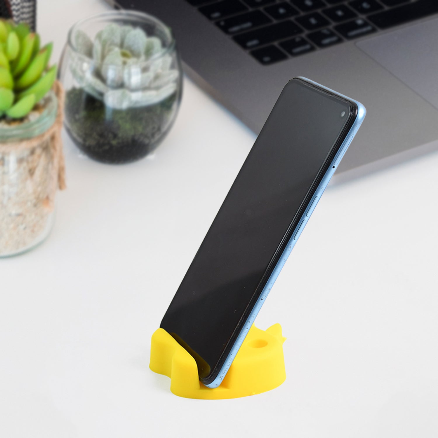 Desk setup featuring apple-shaped mobile stand with pen holder showing colorful pens