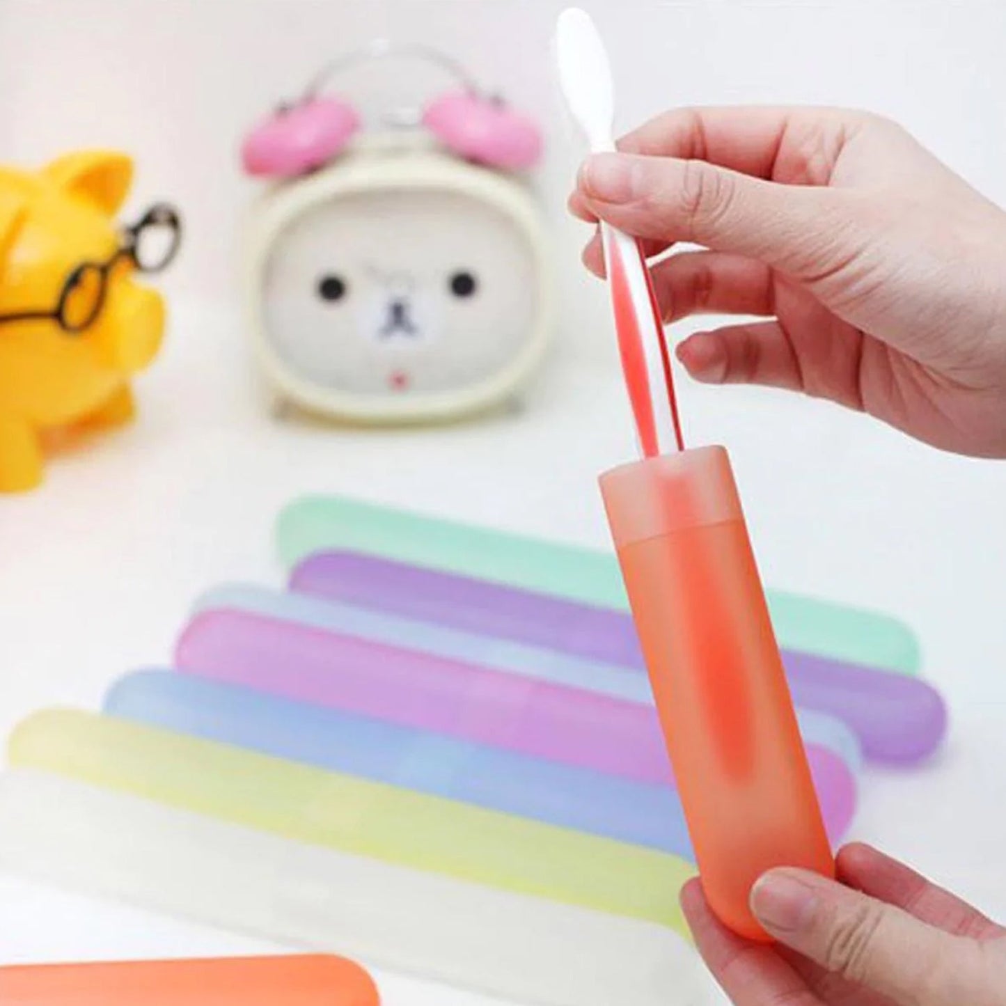 Hand holding a set of lightweight and portable toothbrush covers.