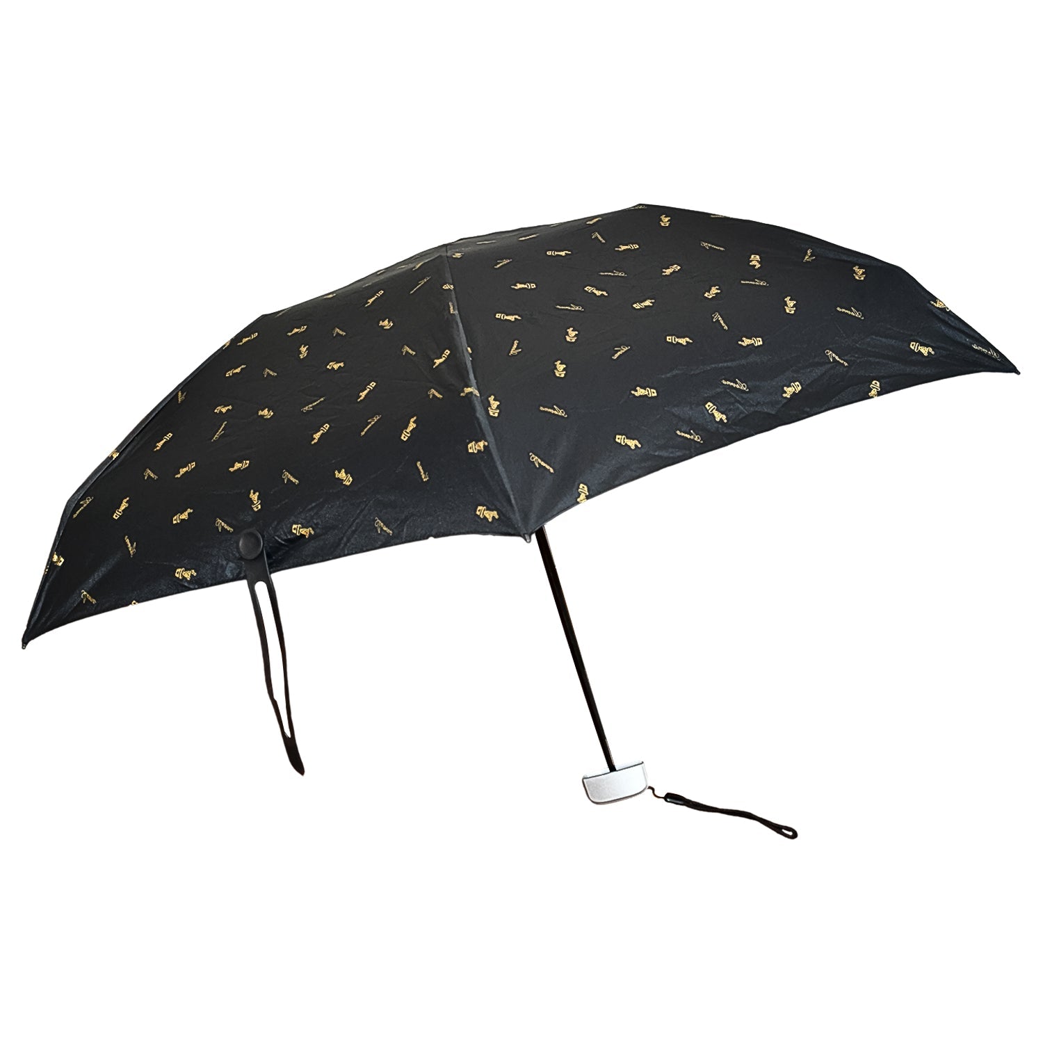 The black compact umbrella is fully open, displaying its gold musical note pattern against a white background.
