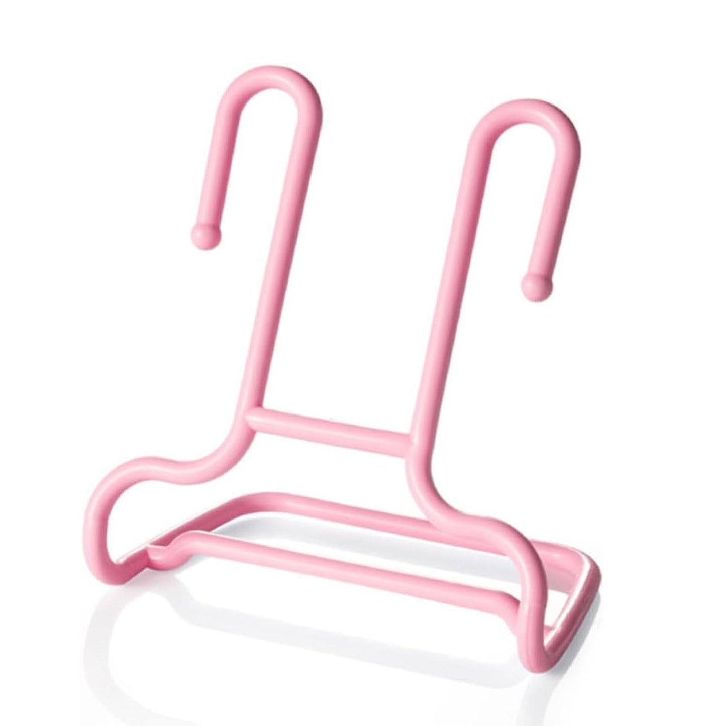 A single pink plastic shoe drying rack is shown against a plain white background with a subtle reflection.