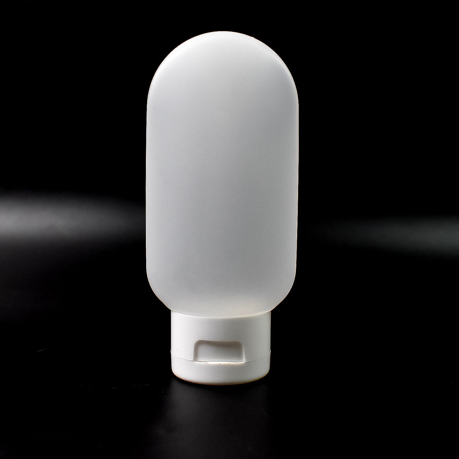 A single 60ml reusable plastic travel bottle in a vibrant mixed color, ready for toiletries.