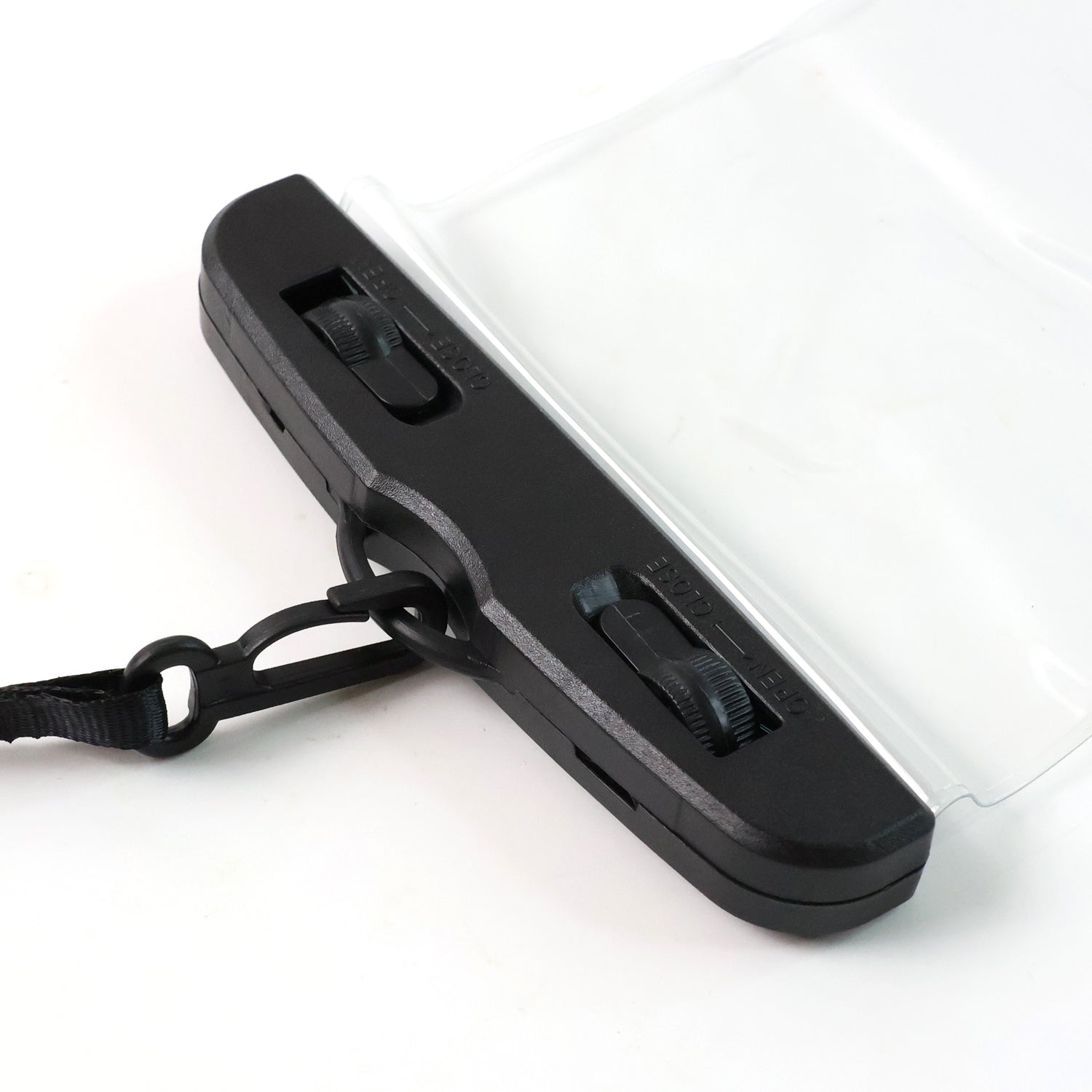 A close-up of the black plastic top of the mobile pouch, showing two sliding latches and a black strap attachment.