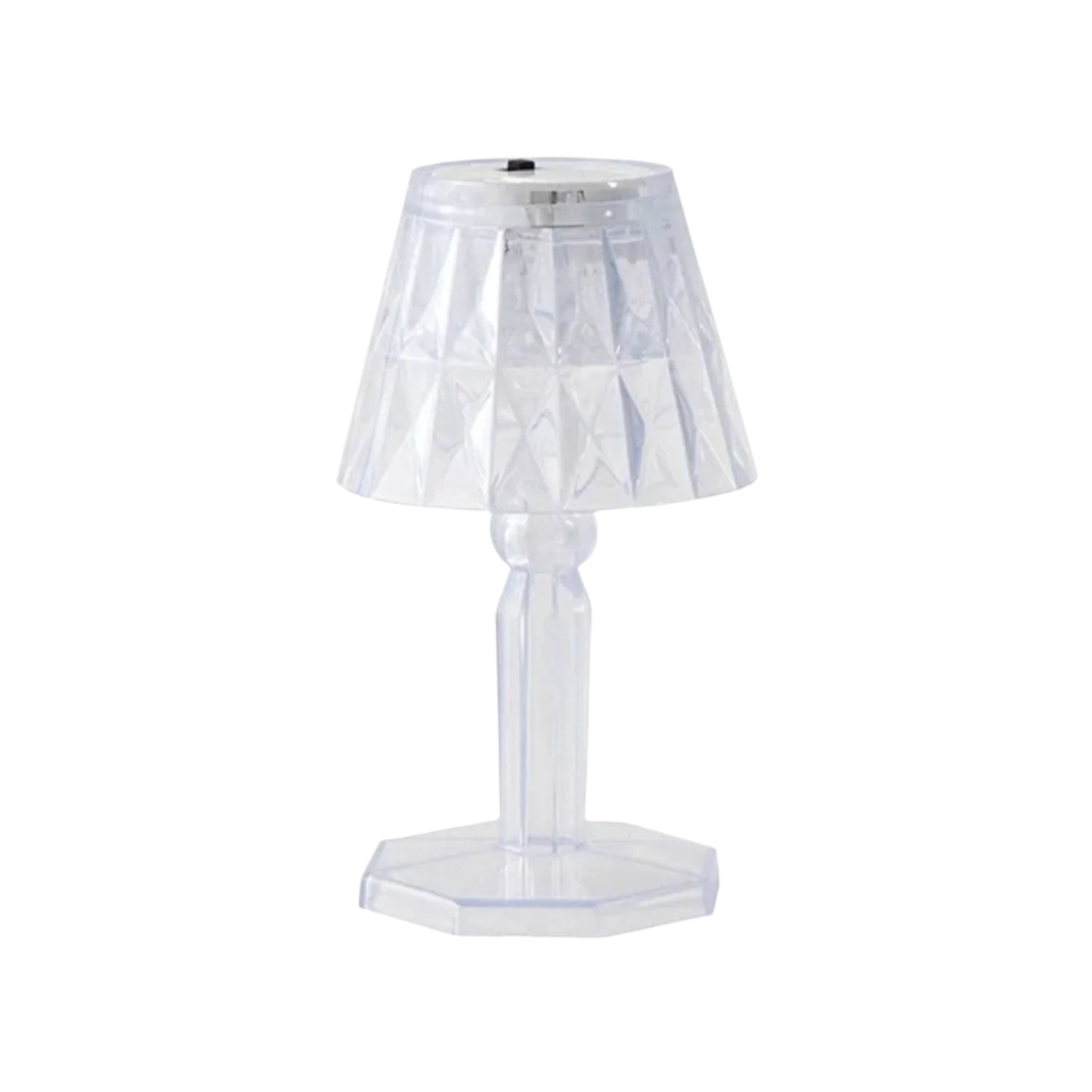 A compact crystal table lamp reflecting light onto a wall.