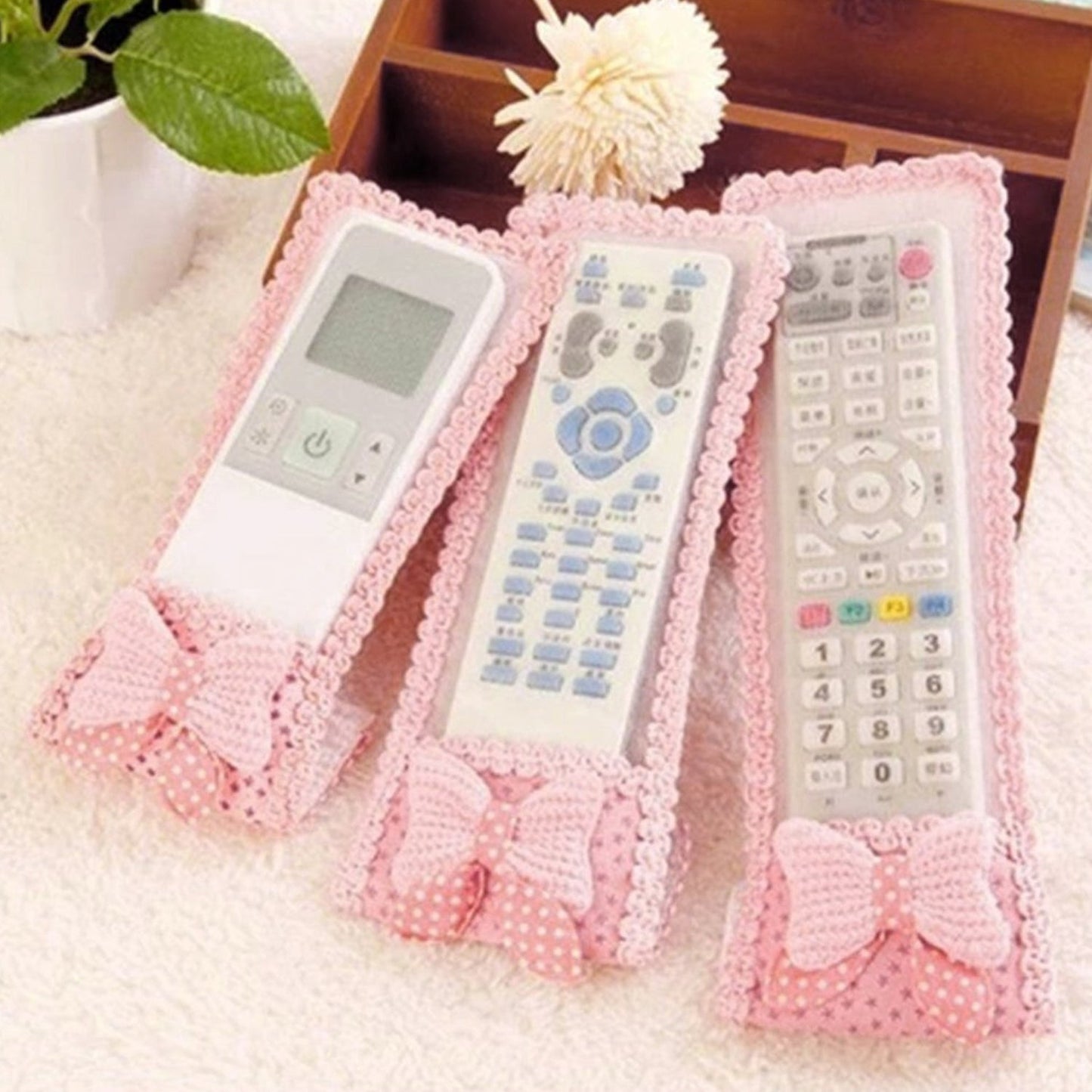 A decorative remote control cover with a bow knot, providing dust protection for TV remotes.