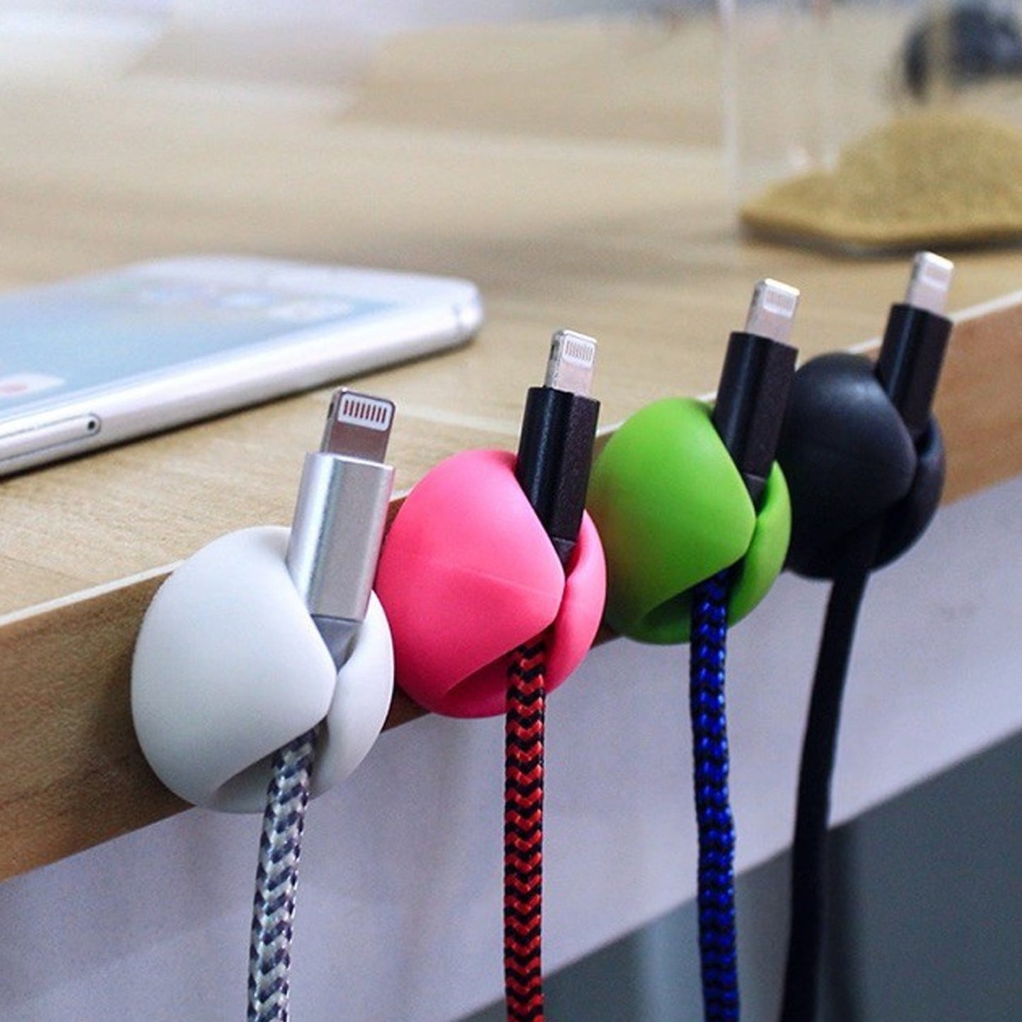 Transparent wire clips for desk organization, blending seamlessly with furniture.