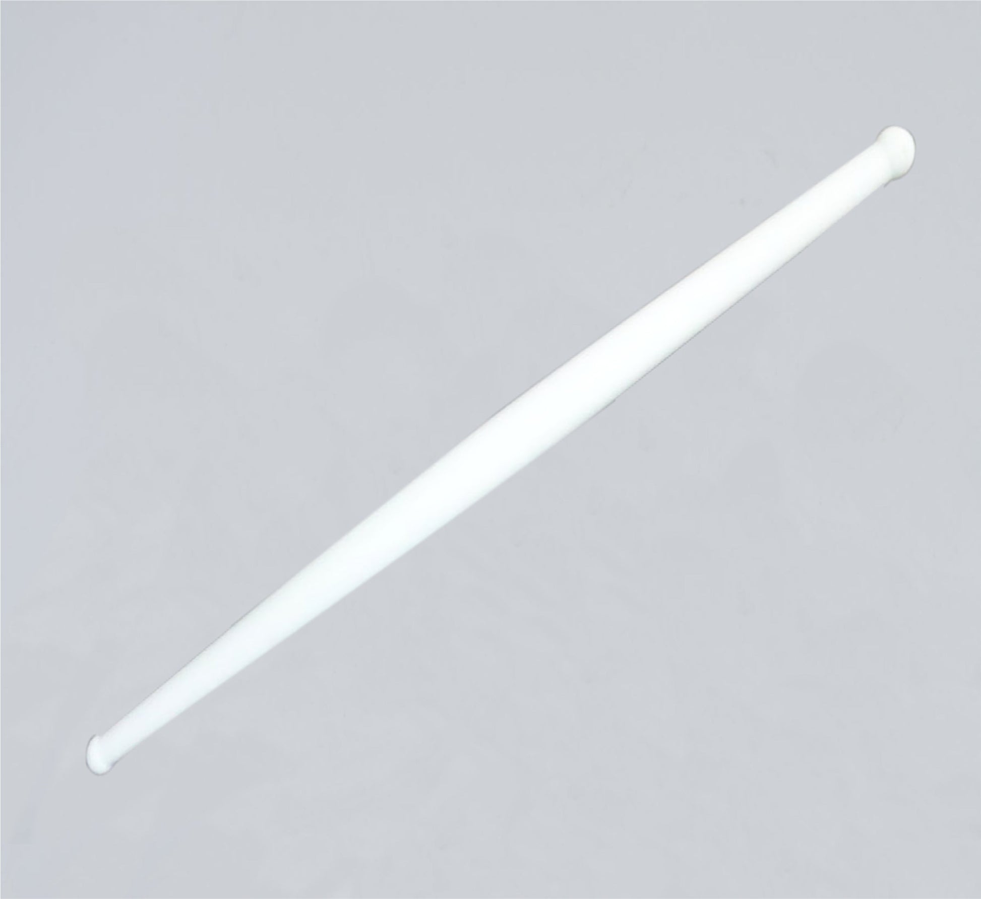 Clean white plastic rolling pin resting on a modern kitchen countertop, ready for use.