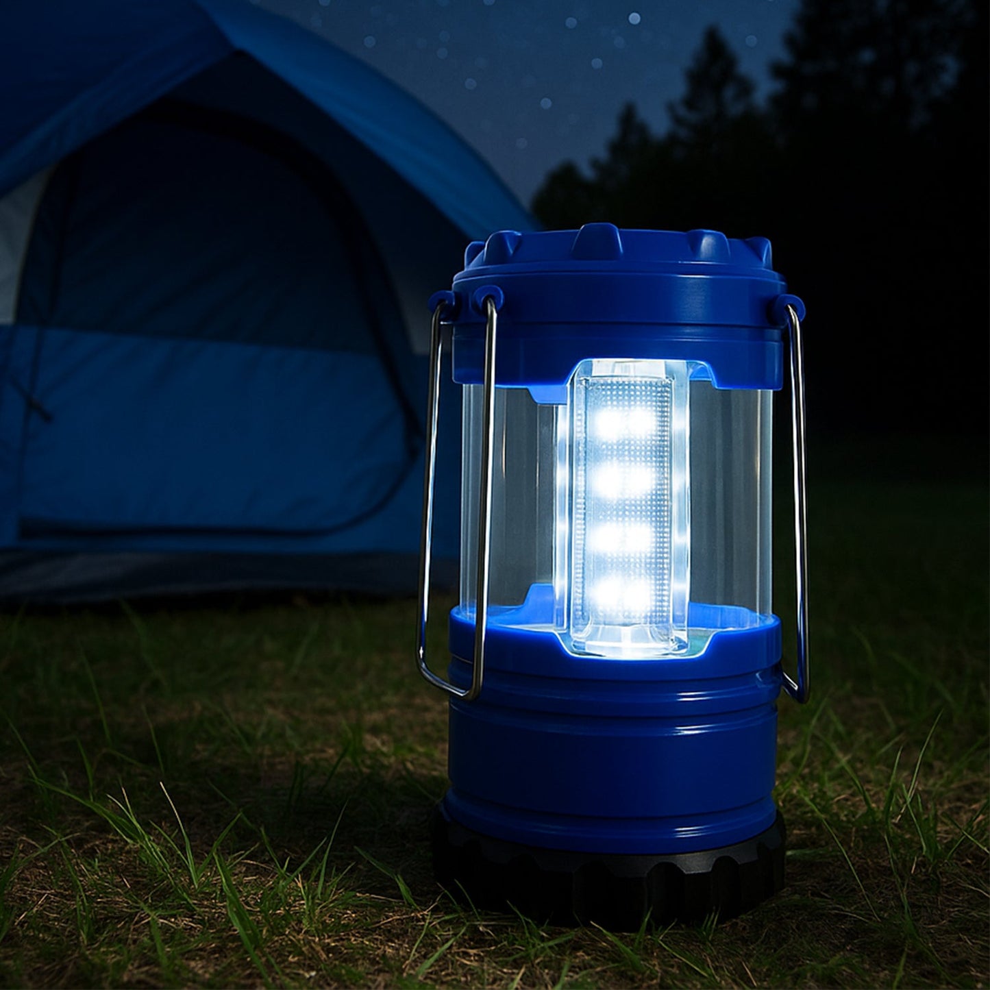 A blue and black LED lantern illuminates a patch of grass in front of a blue tent at night.