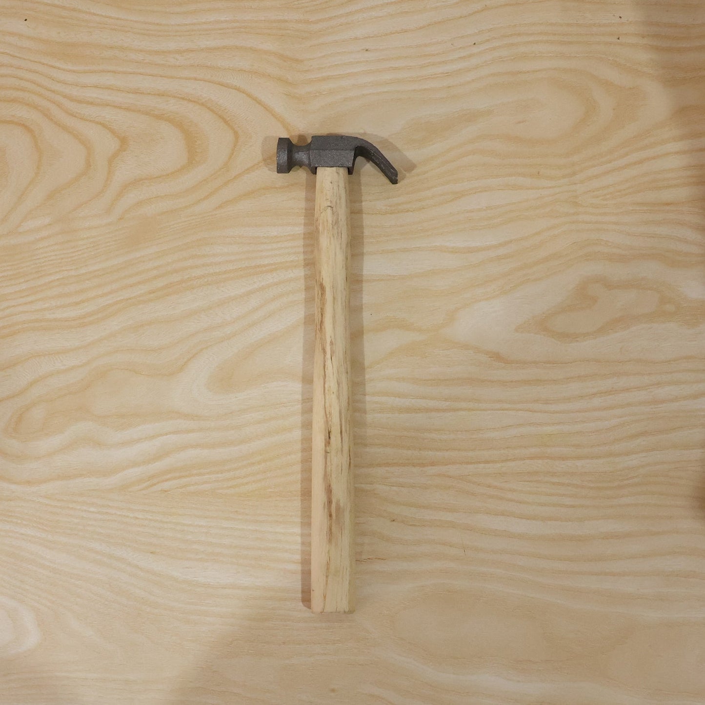 Person using claw hammer to drive a nail in carpentry
