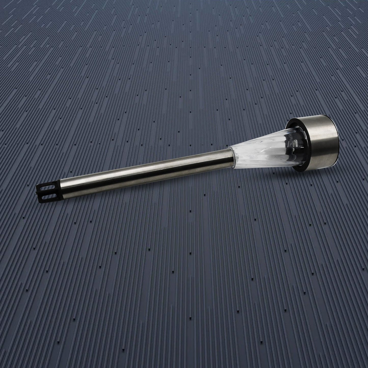 A complete silver and clear plastic solar LED spike light is shown horizontally on a dark blue textured surface.