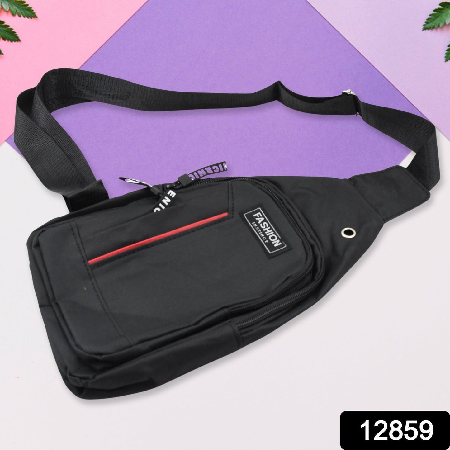 A black polyester sling bag with a red stripe and 'FASHION' label lies on a purple and pink background.