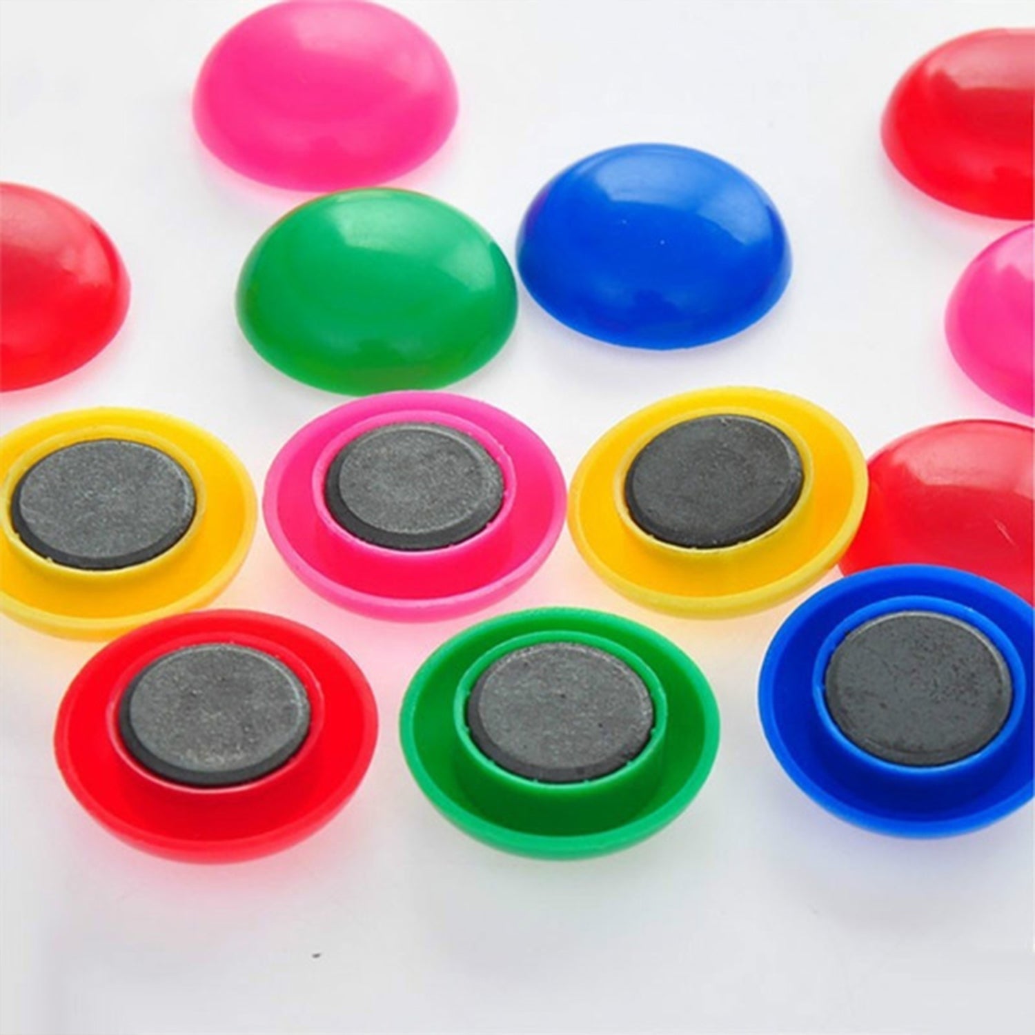 Magnetic buttons for kids arranged on a whiteboard for learning.