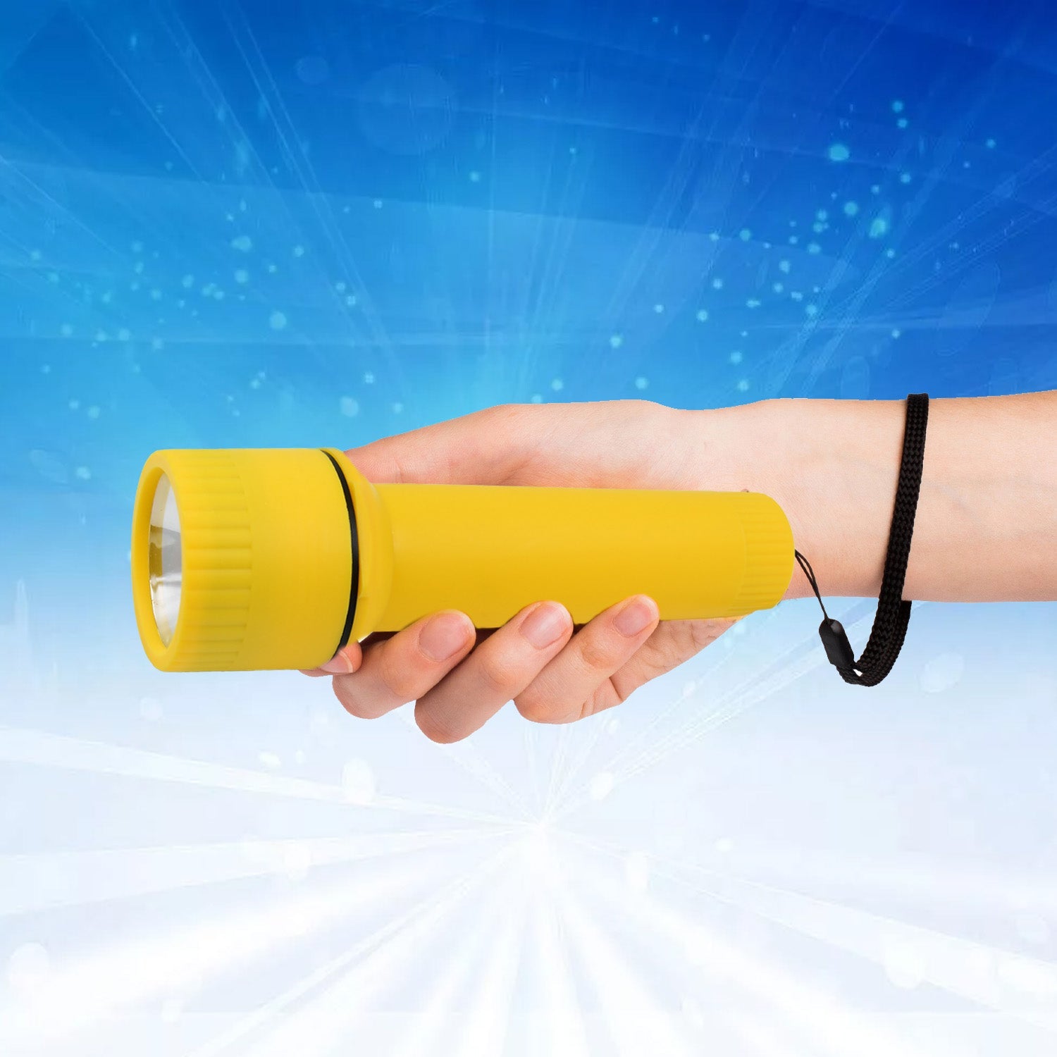 The yellow plastic torch with a black wrist strap stands upright on a dark, textured surface.