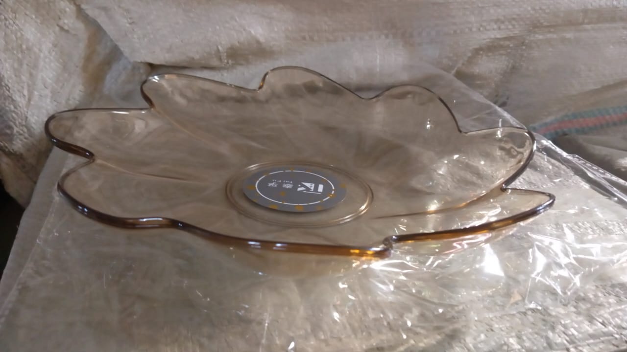 A side view of a flower shaped kids plastic plate, showing its shallow depth suitable for snacks and small meals.