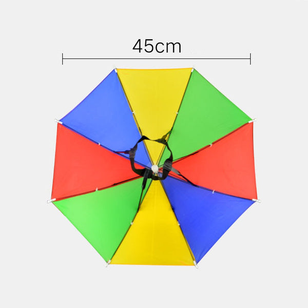 An overhead view of an open, colorful red, yellow, green, and blue umbrella hat with a black elastic headband, measuring