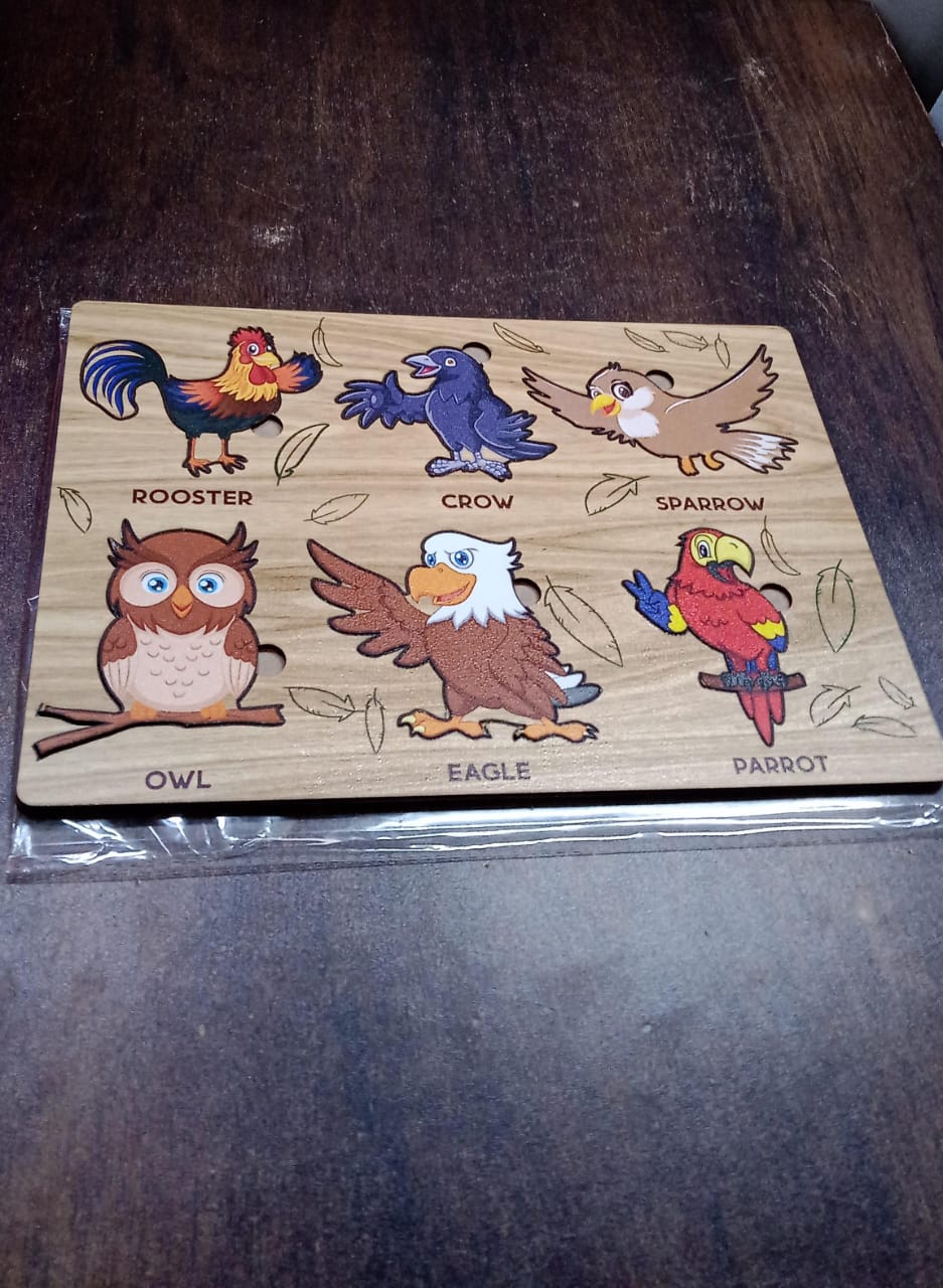 Wooden Bird Puzzle pieces laid out, ready for assembly by a young learner on the board.