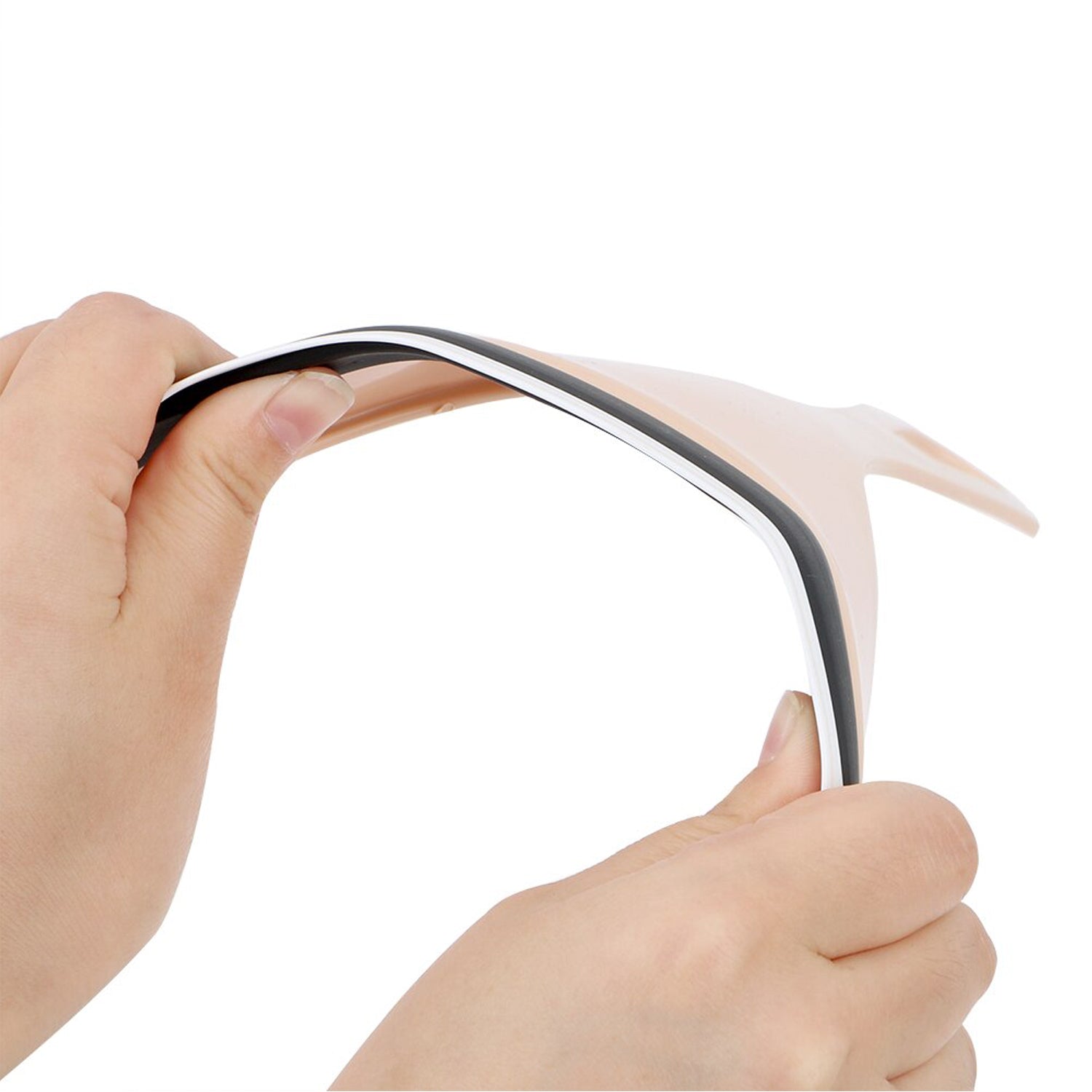 Two hands gently bend the flexible beige car mirror wiper, highlighting its pliable material.