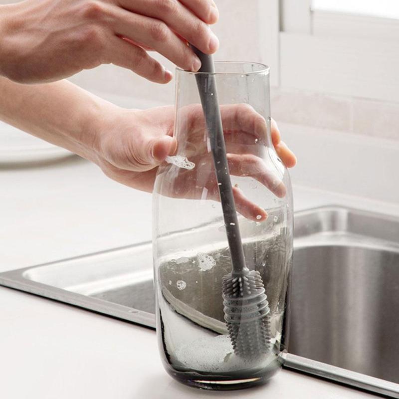 A long-handled bottle cleaning brush with white bristles for deep cleaning.