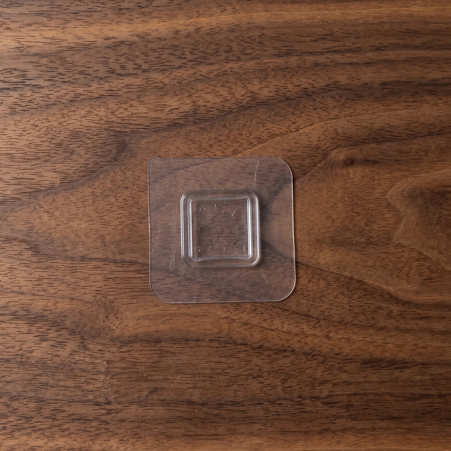 Close-up of a transparent wall sticker hook for discreet storage.