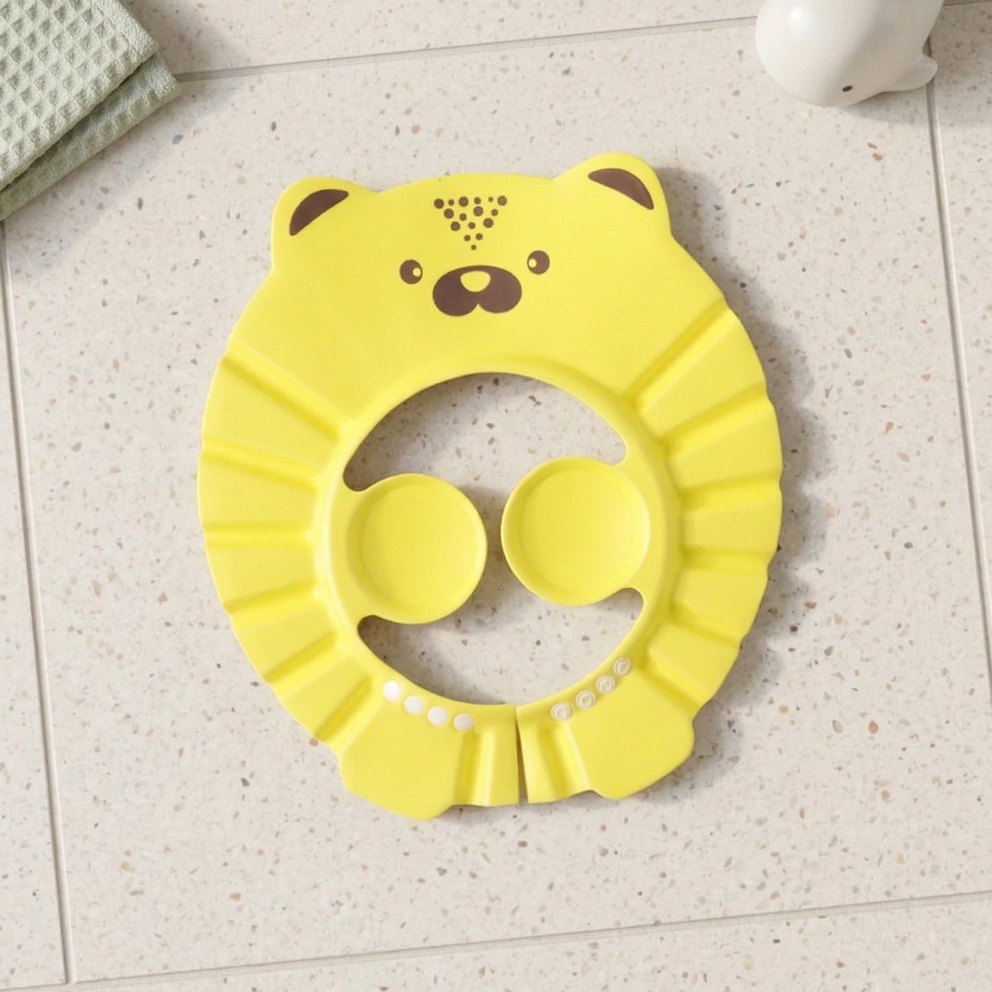An infant wears a baby bath hair protection hat, made from soft waterproof material for gentle care.