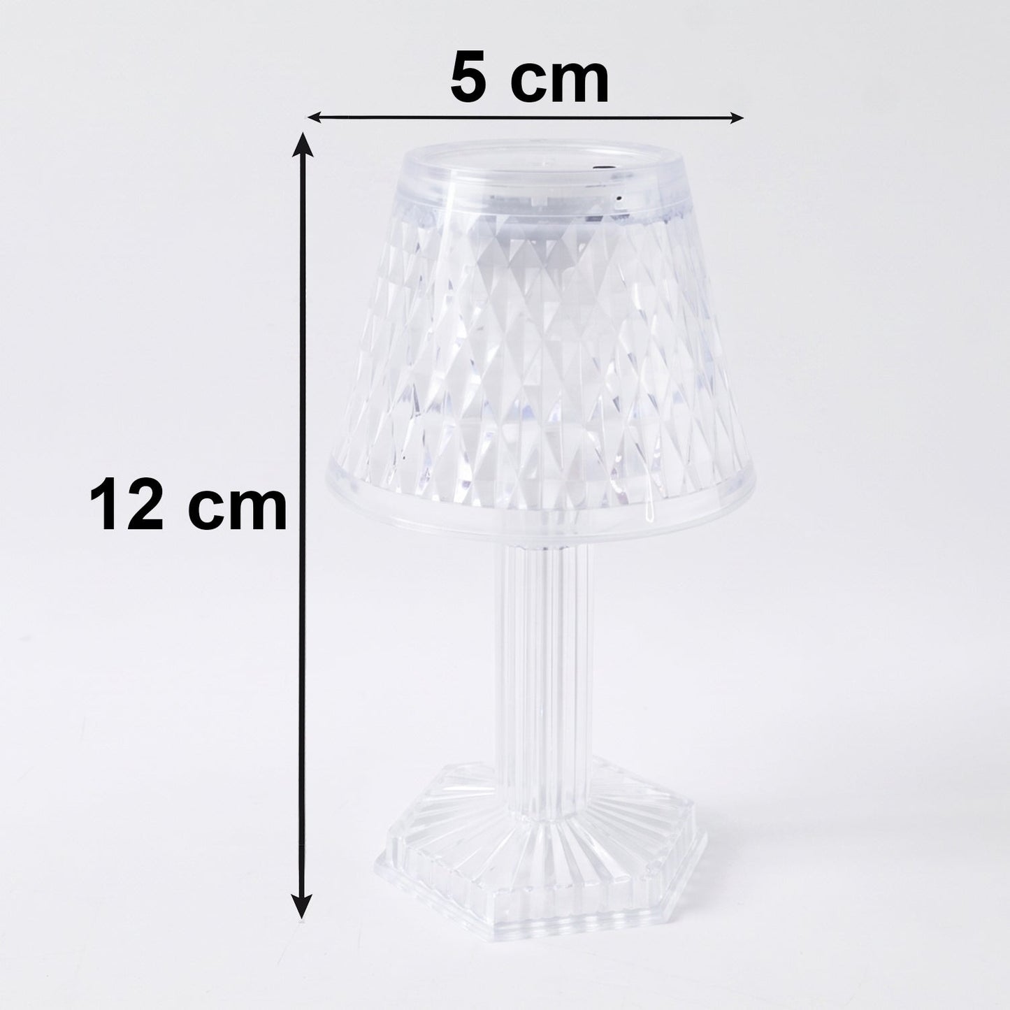 Small crystal table lamp creating a warm, ambient glow in a dark room.