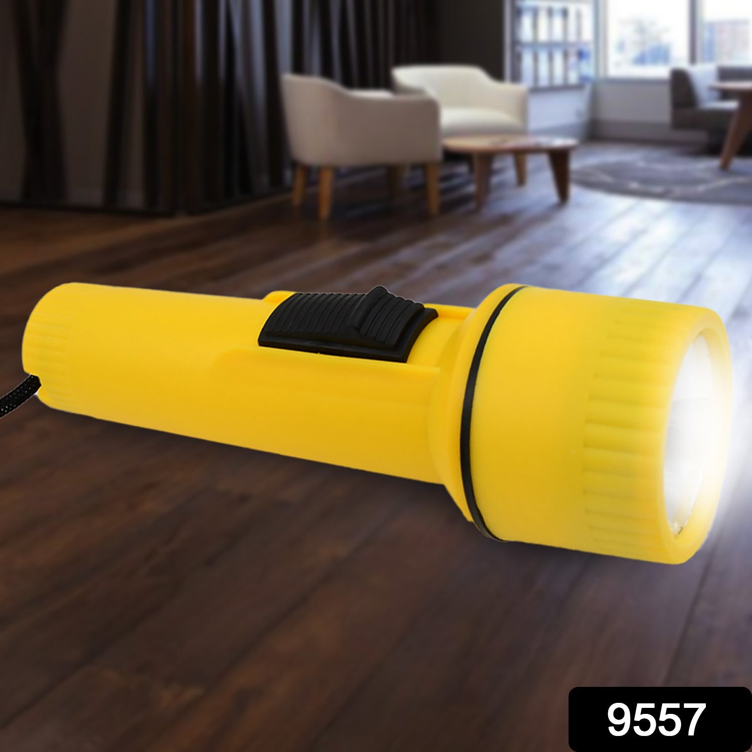 A bright yellow plastic torch with a black switch illuminates a dark wooden floor in a living room setting.