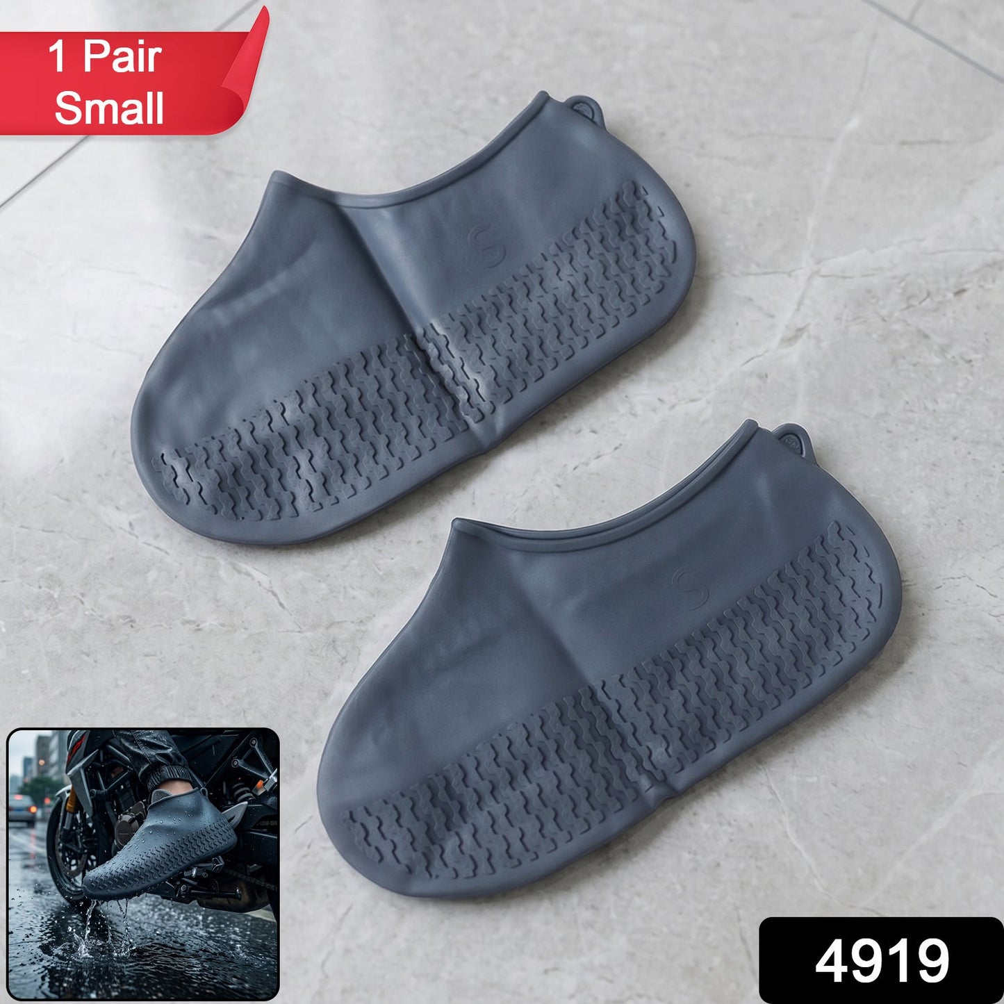 A pair of gray silicone foot coverings with textured soles on a tiled floor, with a red
