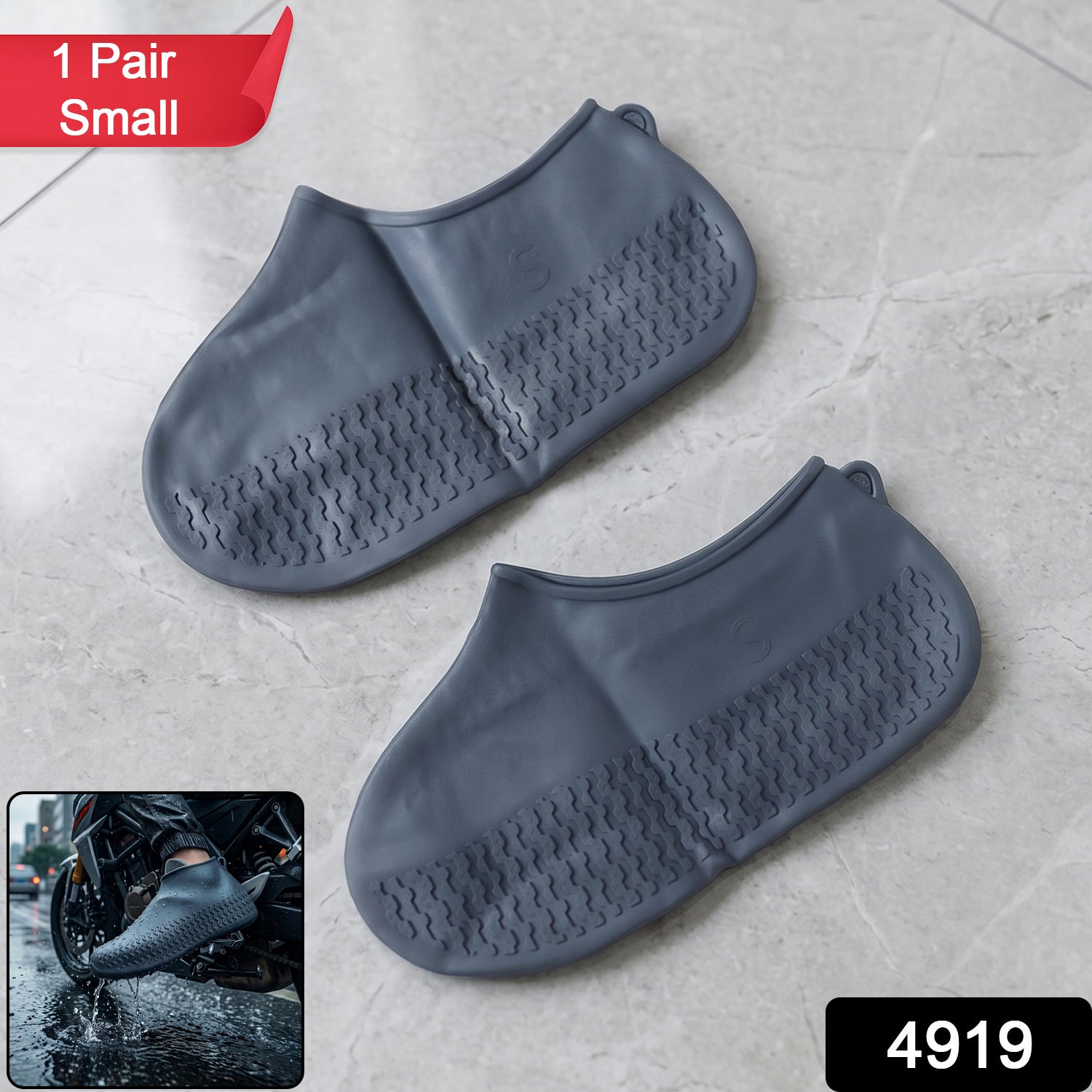 A pair of gray silicone foot coverings with textured soles on a tiled floor, with a red