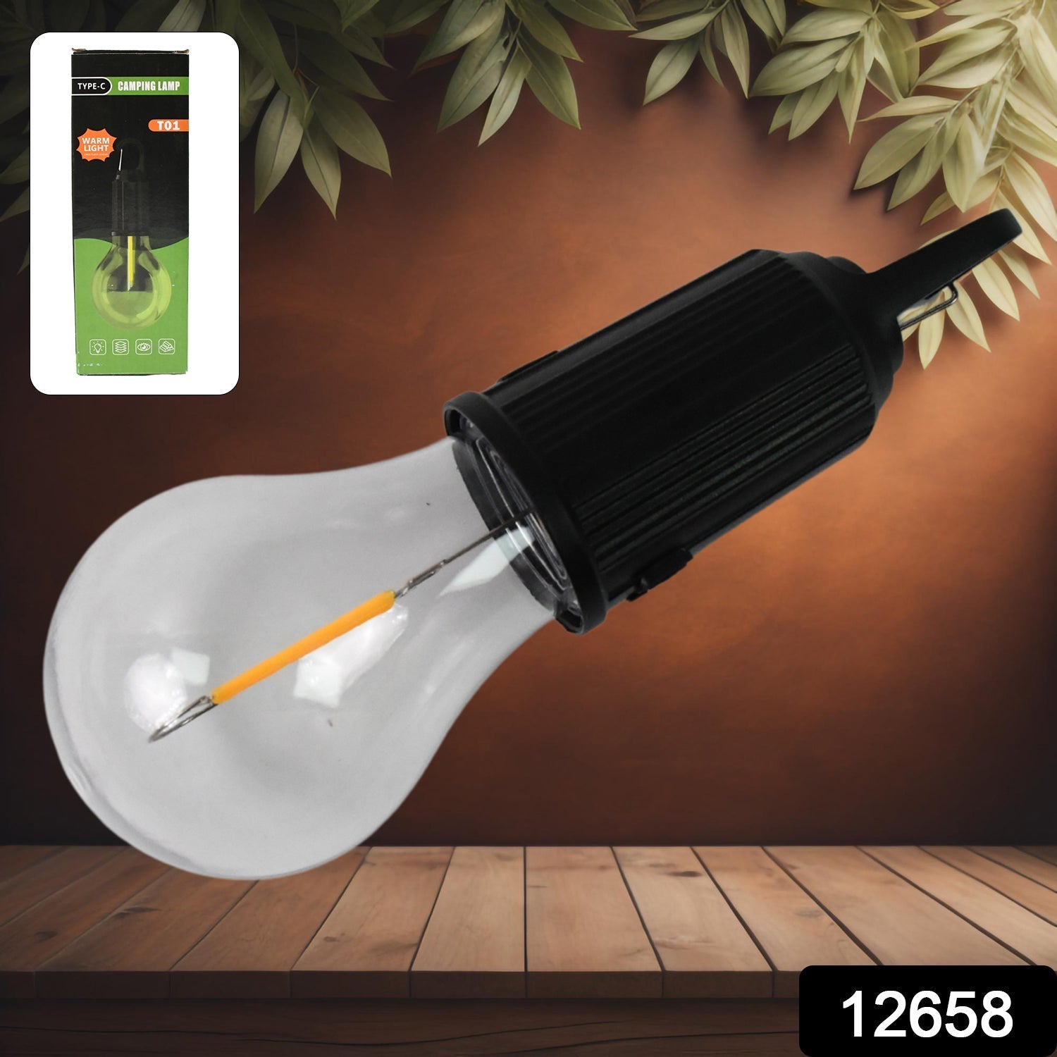 A black and clear portable LED tent light with an orange filament lies diagonally on a wooden surface, with its green and